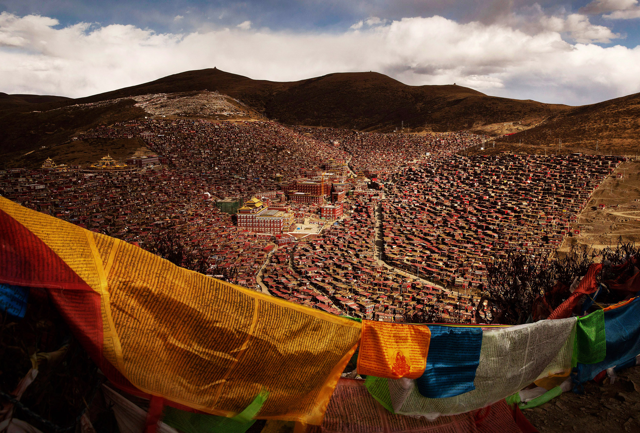 Tibetan prayer flags flutter on a hillside above the Larung Wuming Buddhist Institute on Oct. 30.