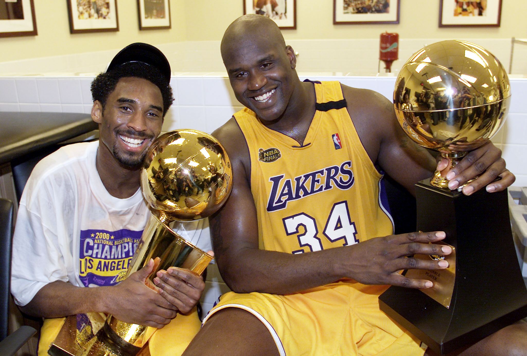 LOS ANGELES, UNITED STATES: Kobe Bryant (L) of the Los Angeles Lakers holds the Larry O'Brian trophy as teammate Shaquille O'Neal (L) hold the MVP trophy after winning the NBA Championship against Indiana Pacers 19 June, 2000, after game six of the NBA Finals at Staples Center in Los Angeles, CA. The Lakers won the game 116-111 to take the NBA title 4-2 in the best-of-seven series. (ELECTRONIC IMAGE) AFP PHOTO (Photo credit should read AFP/AFP/Getty Images)