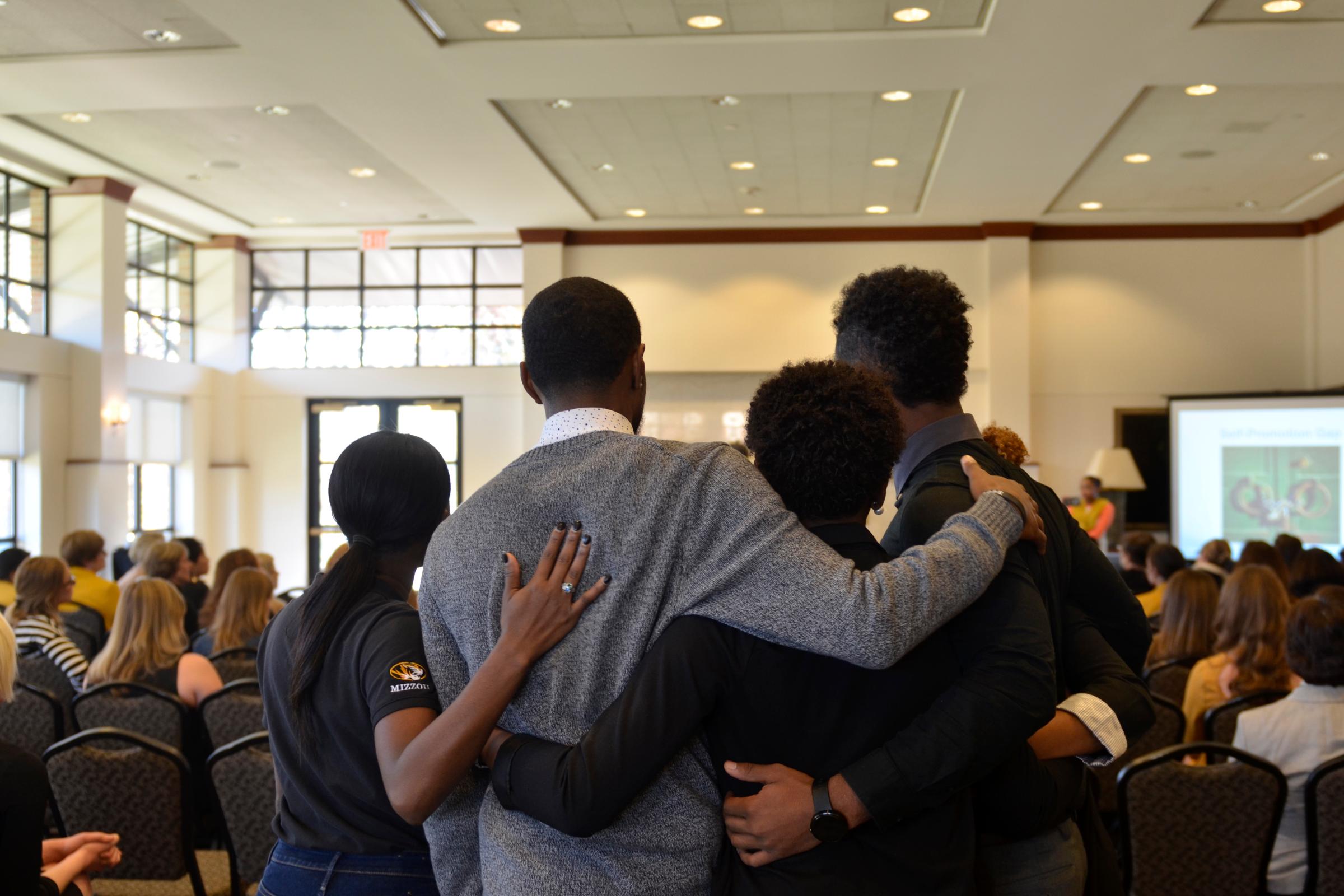 Members of Concerned Student 1950 embrace during a protest in the Reynolds Alumni Center on Nov. 7, 2015. The alumni center was one of many stops the students took during a traveling protest to voice concerns.