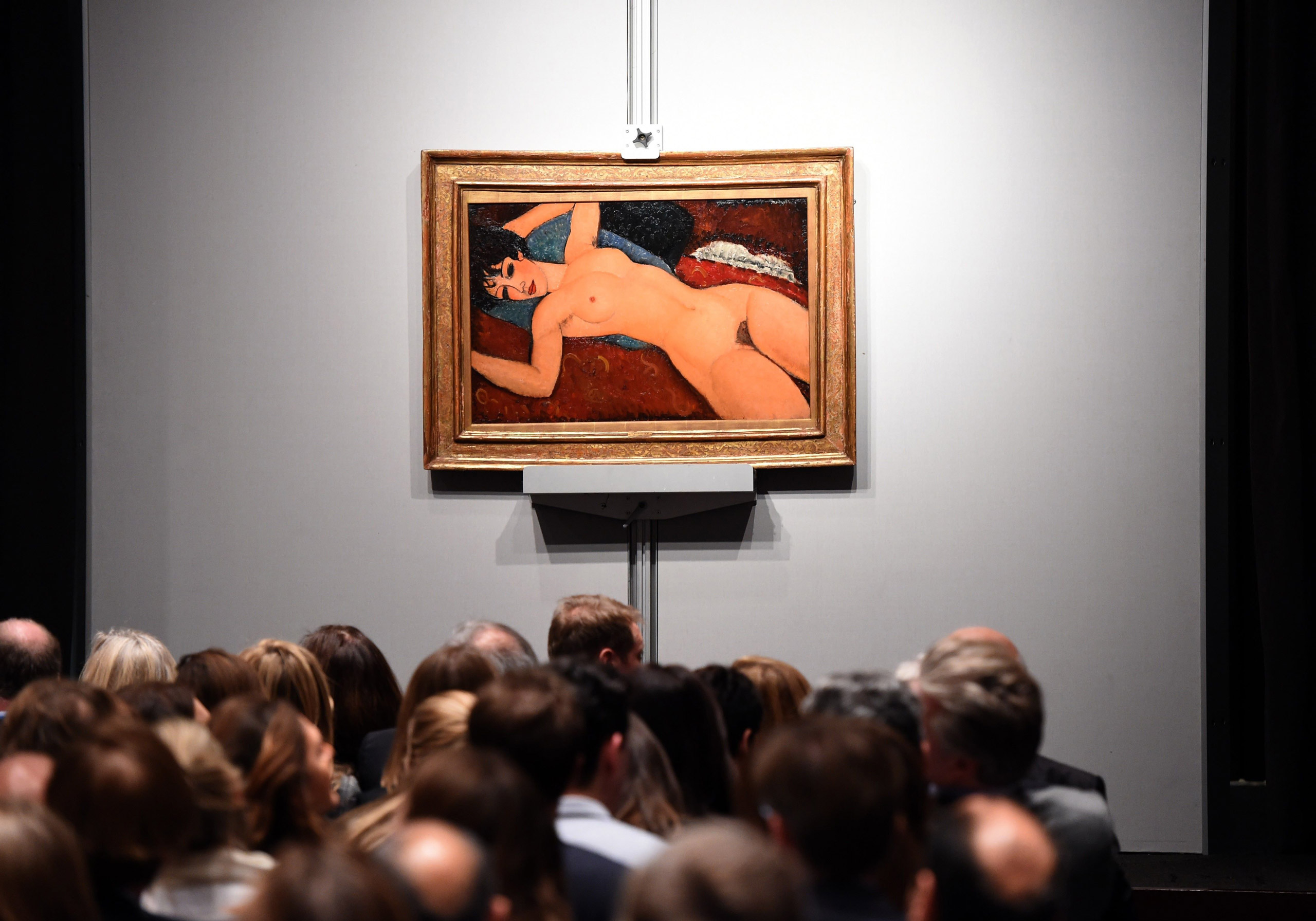 Crowds sit in front of Amedeo Modigliani's "Nu couche" during the "Artist Muse: A Curated Evening Sale" at Christie's in New York on Nov. 9, 2015. (Timothy A. Clary—AFP/Getty Images)