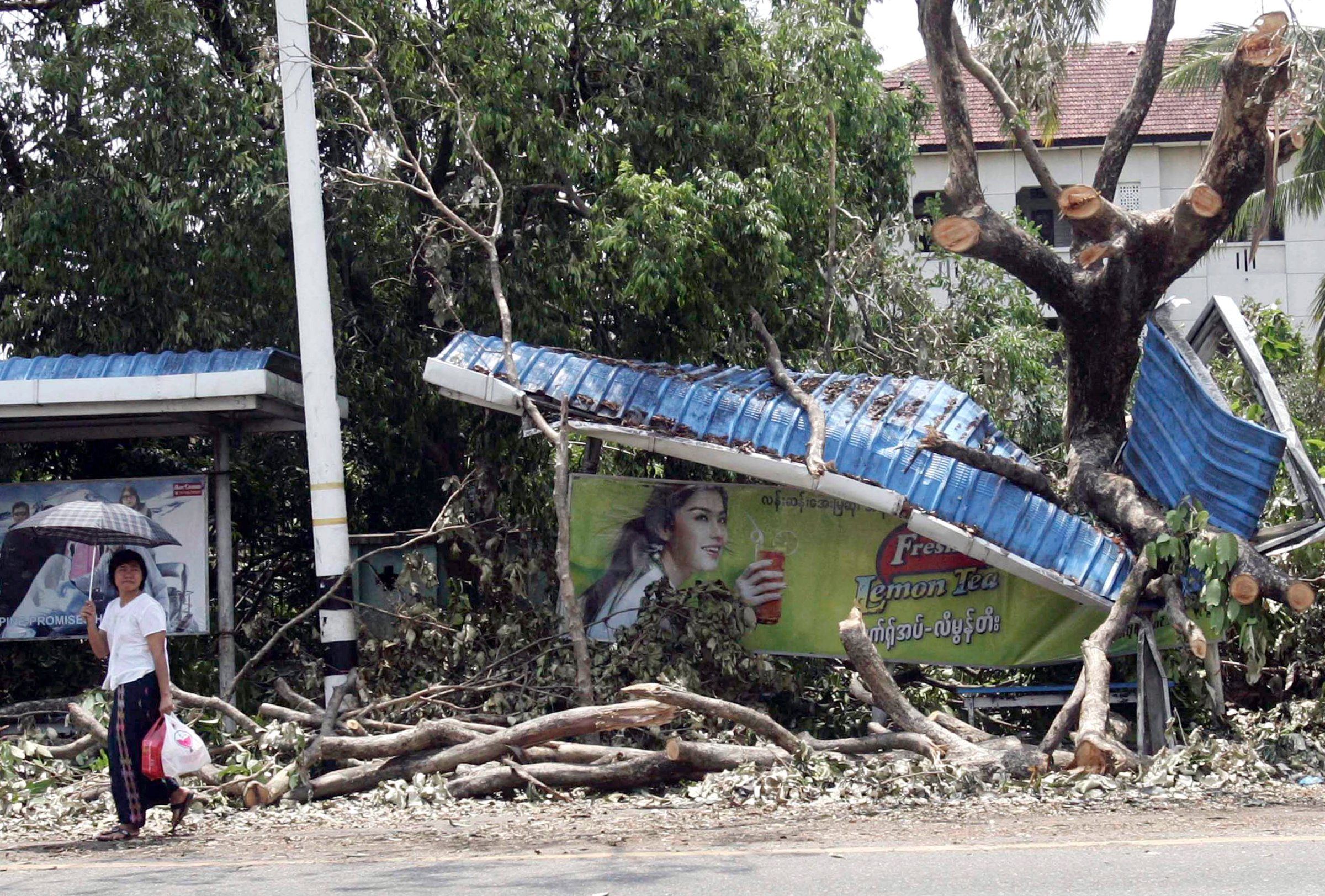 A Myanmar girl makes her way past a bus station destroyed by the cyclone that hit Yangon on May 6, 2008.