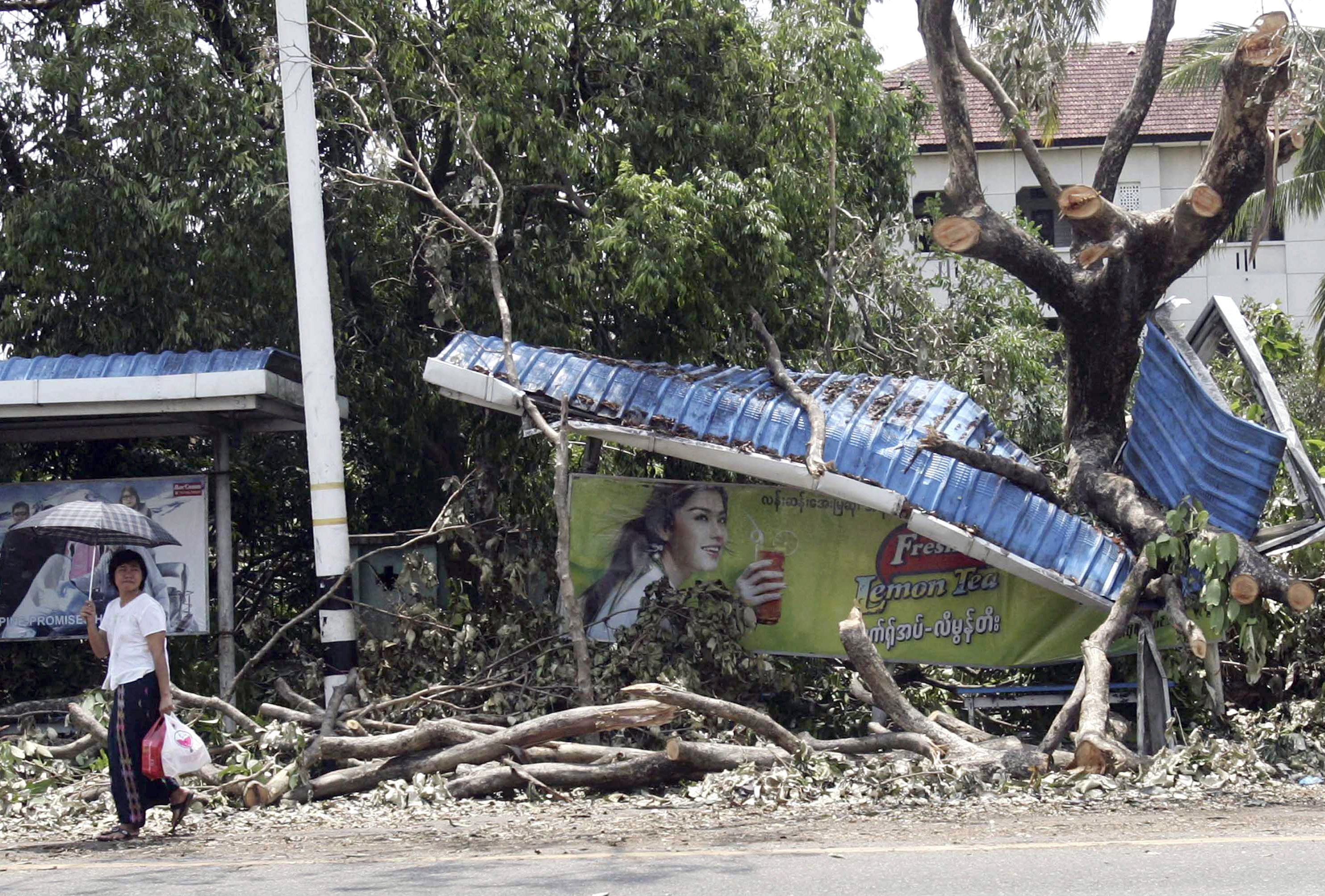 A Myanmar girl makes her way past a bus station destroyed by the cyclone that hit Yangon on May 6, 2008. (Associated Press)