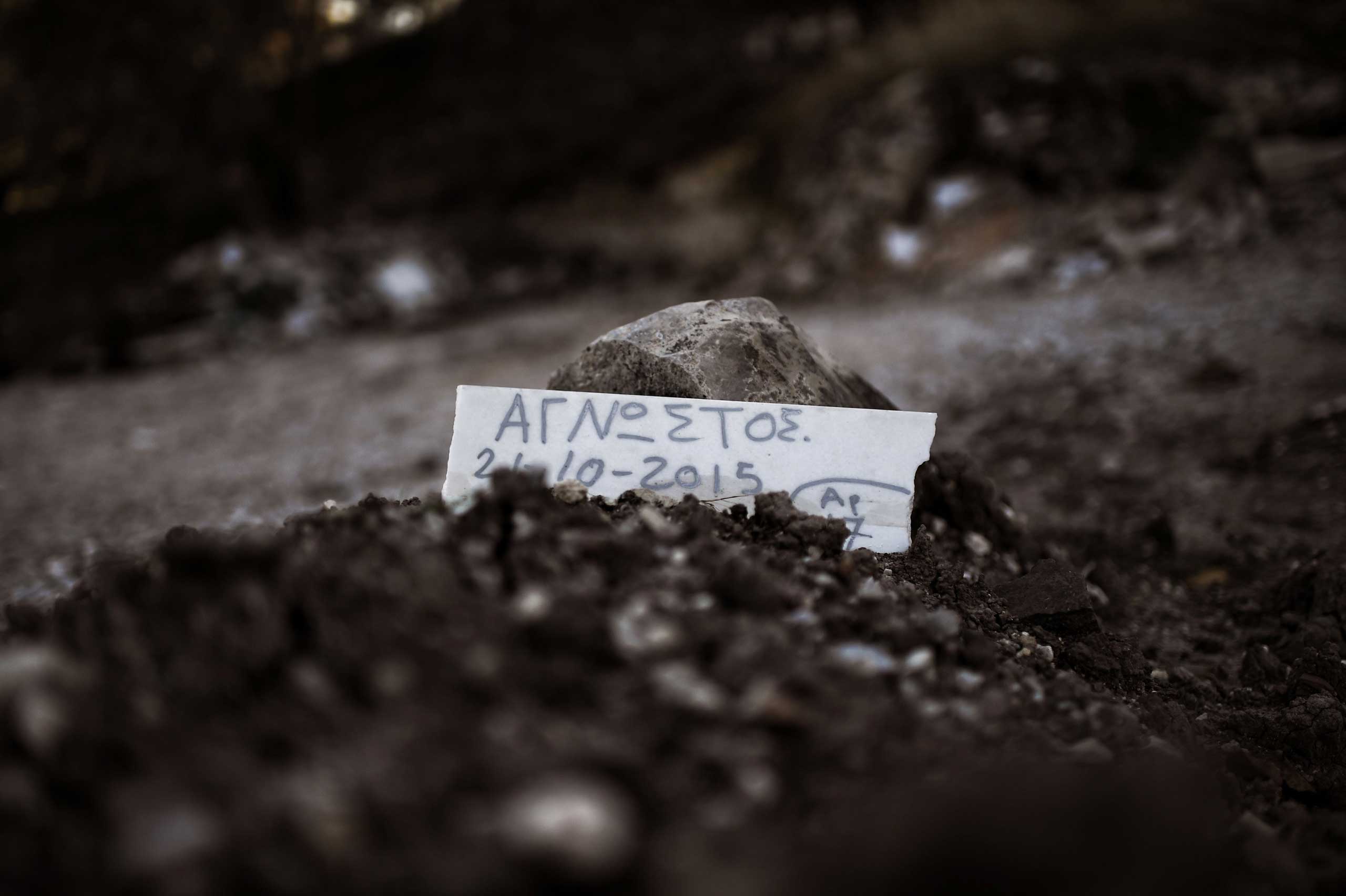 A piece of marble reading 'Unidentified' is placed over the grave of a person who drowned on the way from Turkey to the Greek island of Lesbos, at a makeshift cemetery in Mytiline, on the Geek island of Lesbos, on Nov. 4, 2015. (Aris Messinis—AFP/Getty Images)