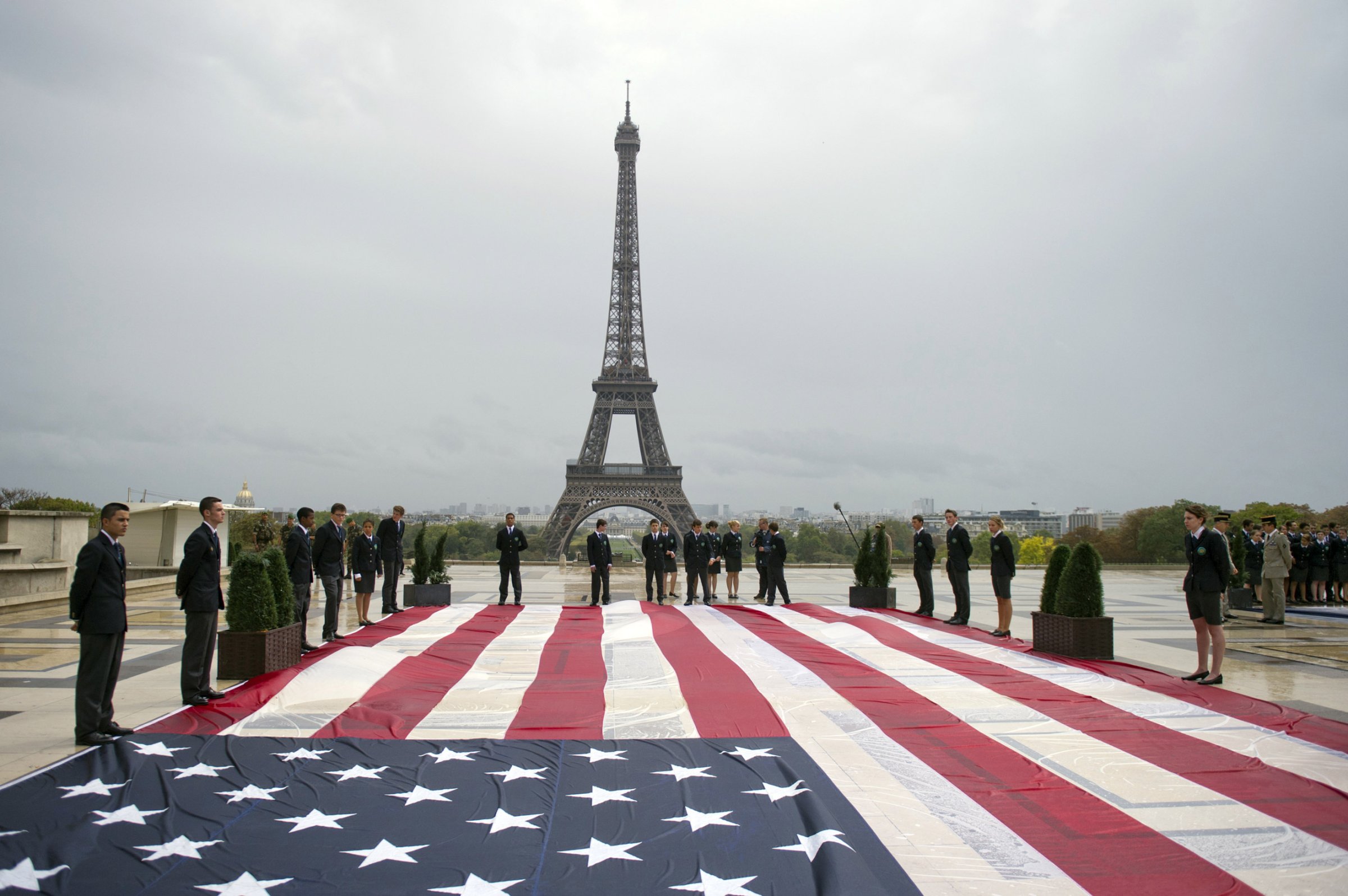 Student officers display an American flag on the Trocadero square with the Eiffel tower in the background during a solemn tribute to the victims of the 9/11 attacks on Sept. 11, 2011 in Paris.