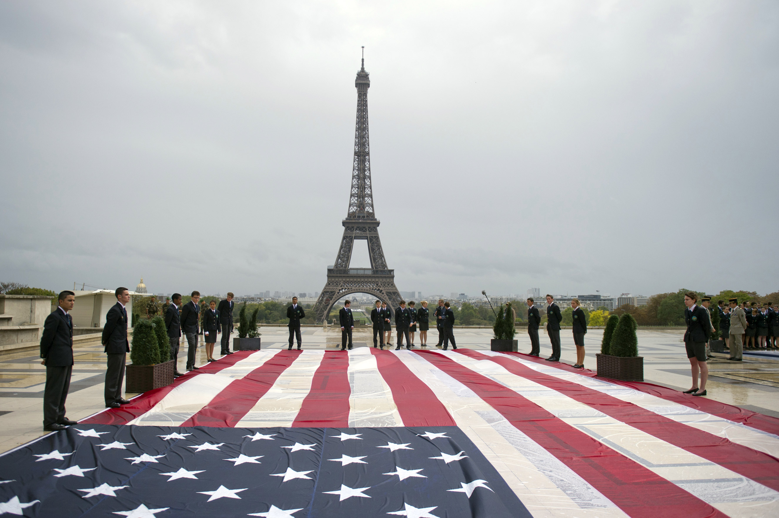 Student officers display an American flag on the Trocadero square with the Eiffel tower in the background during a solemn tribute to the victims of the 9/11 attacks on Sept. 11, 2011 in Paris. (Fred Dufour—AFP/Getty Images)