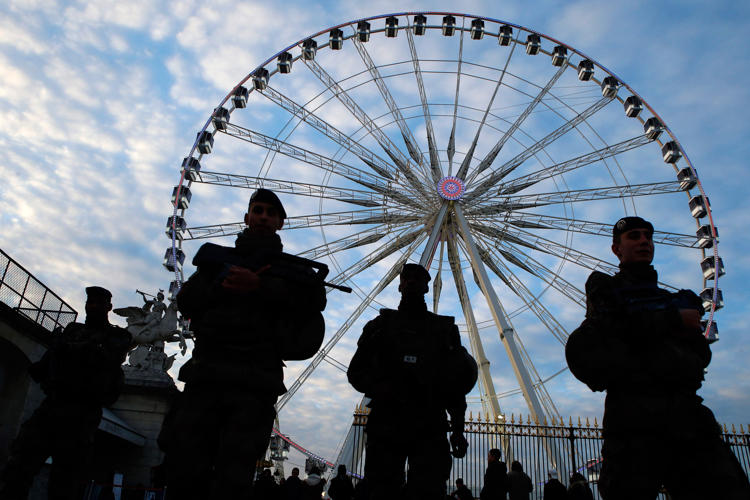 French soldiers patrol in front of the Paris ferris Big Wheel next to the Champs Elysees, in Paris, France, Sunday, Nov. 22, 2015 one week after the Paris attacks. French Defense ministry announced that there are currently 10,000 soldiers deployed in France as part of security measures put in place in the wake of the attacks, including 6,500 in the Paris region.(AP Photo/Francois Mori)