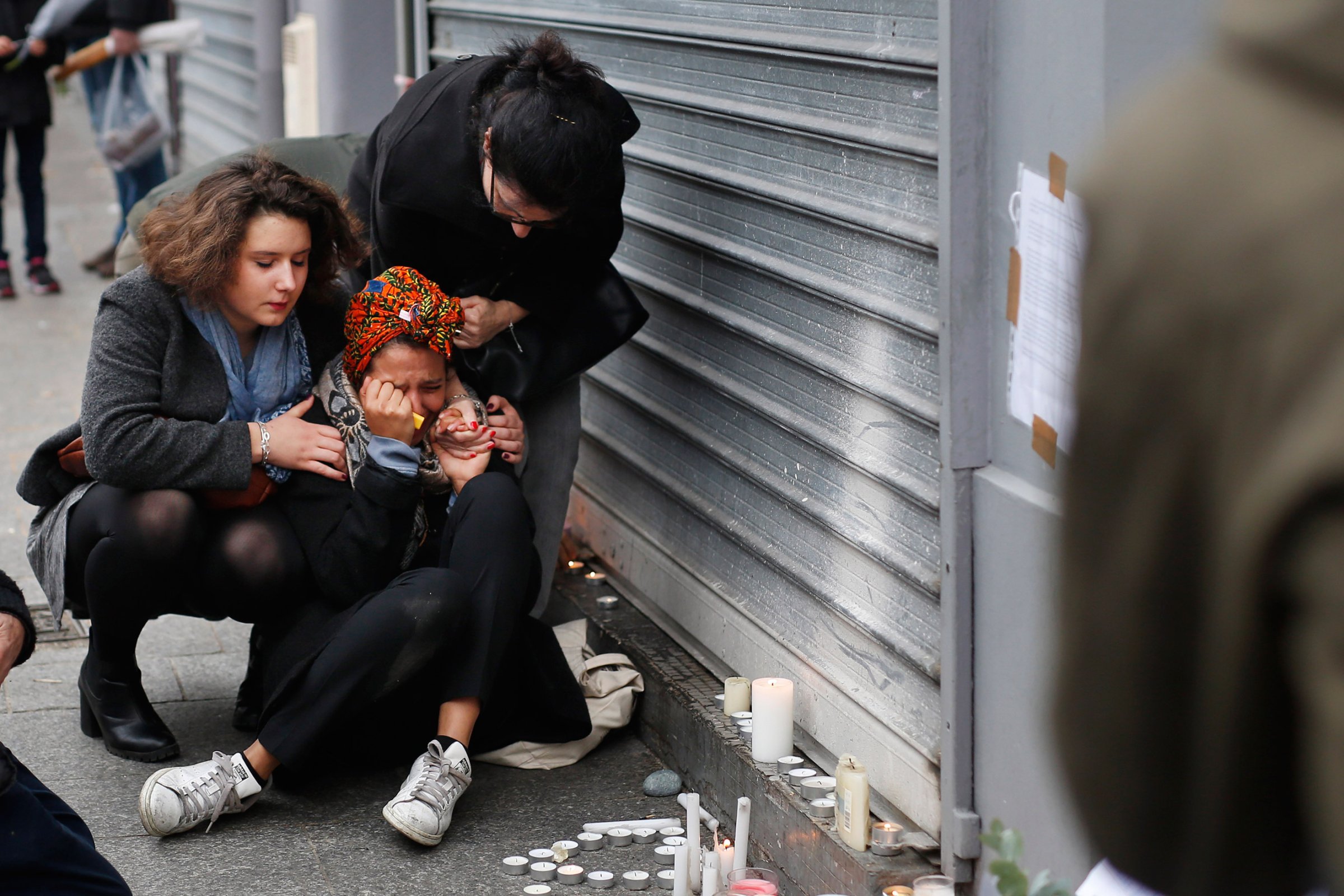 A woman is comforted by others outside the Carillon cafe and the Petit Cambodge restaurant in Paris on Nov. 14, 2015.