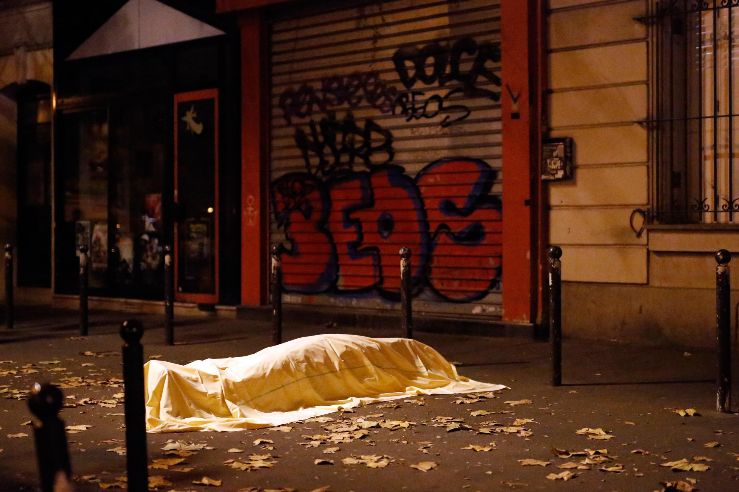 A victim under a blanket lays dead outside the Bataclan theater in Paris on Nov. 13, 2015.