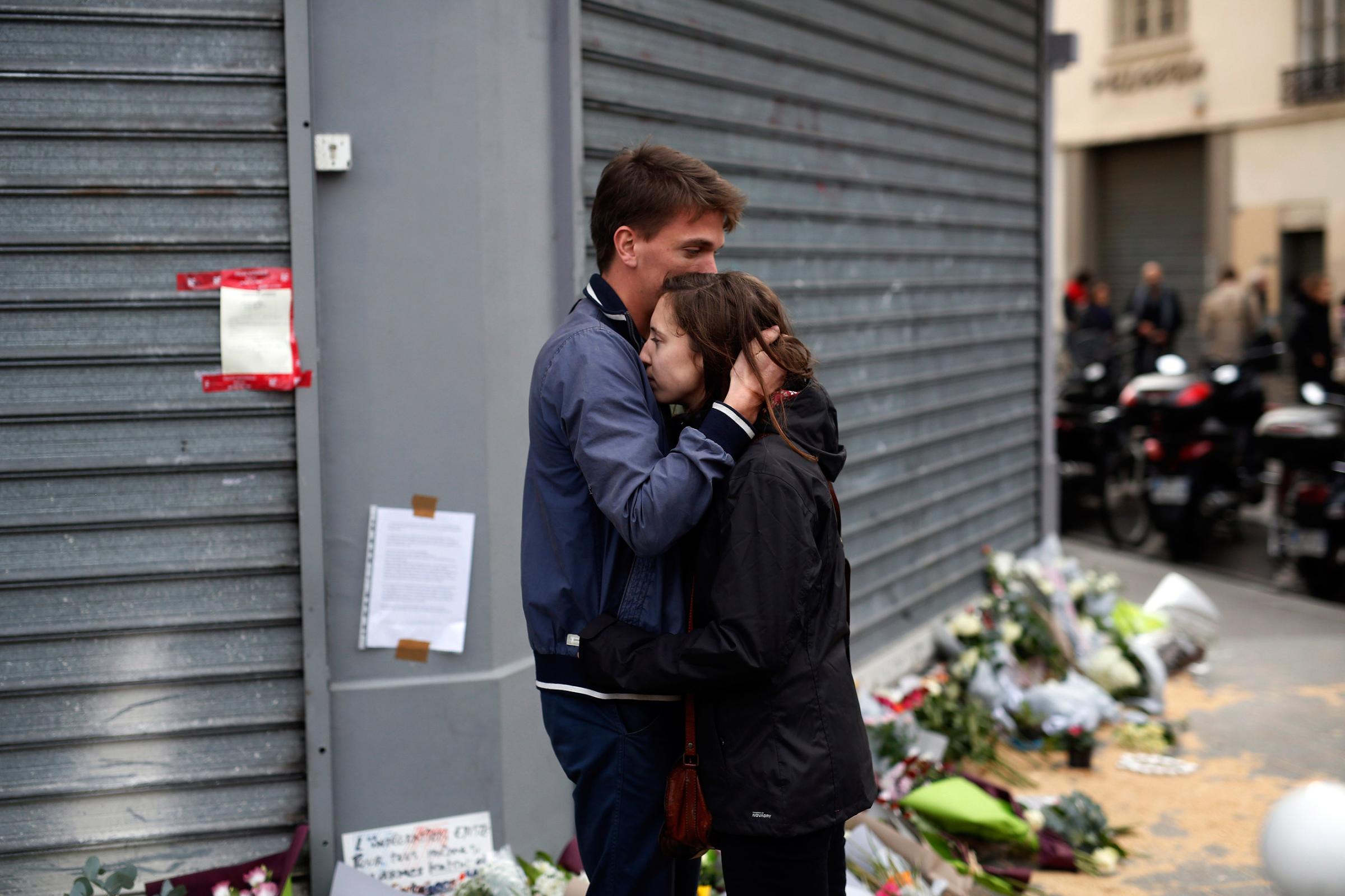 People react in front of the Carillon cafe and the Petit Cambodge restaurant in Paris on Nov. 14, 2015.