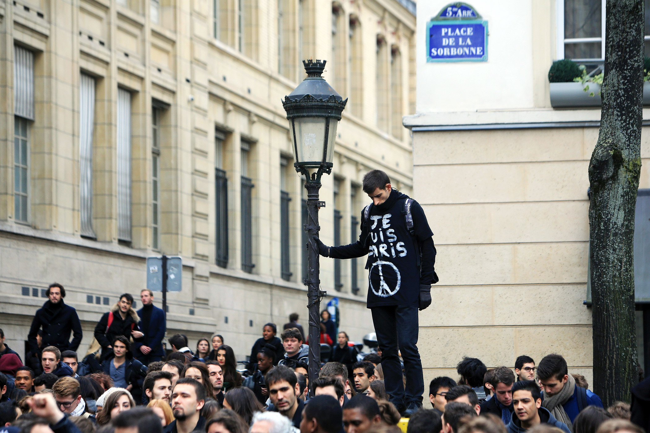A man wears a shirt that says "I am Paris" during a minute of silence, outside the Sorbonne University.
