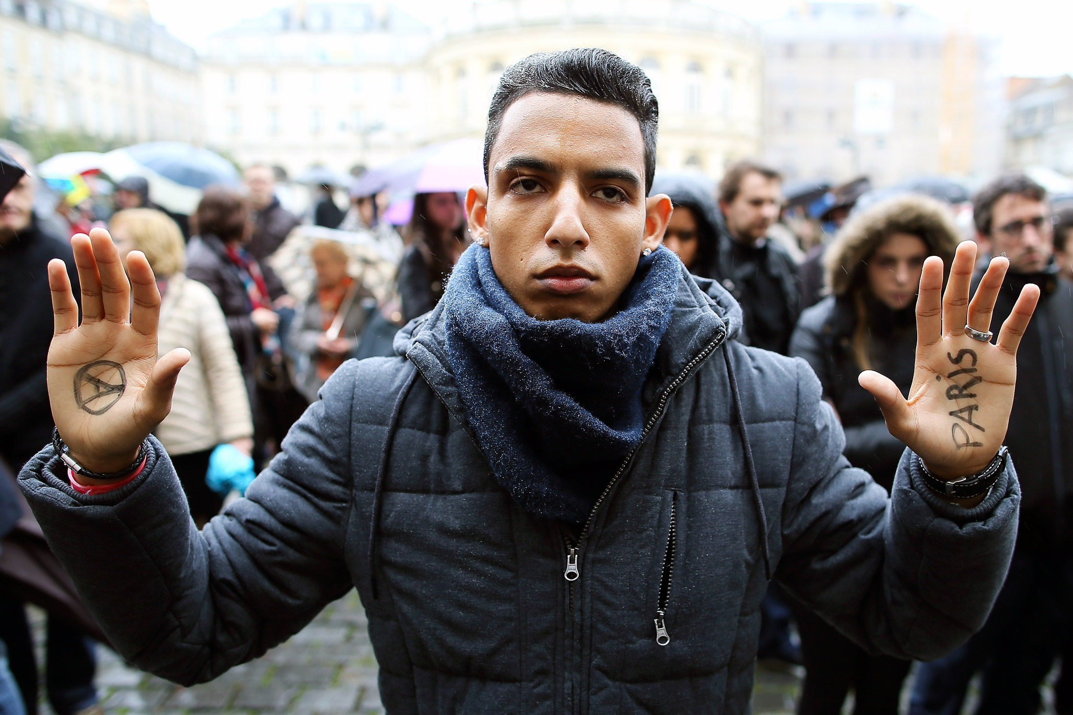 A man holds up his hands during a minute of silence for victims of Paris attacks in Rennes, western France.