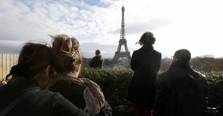 People observe a minute of silence at the Trocadero in front the Eiffel Tower to pay tribute to the victims of the series of deadly attacks on Friday in Paris
