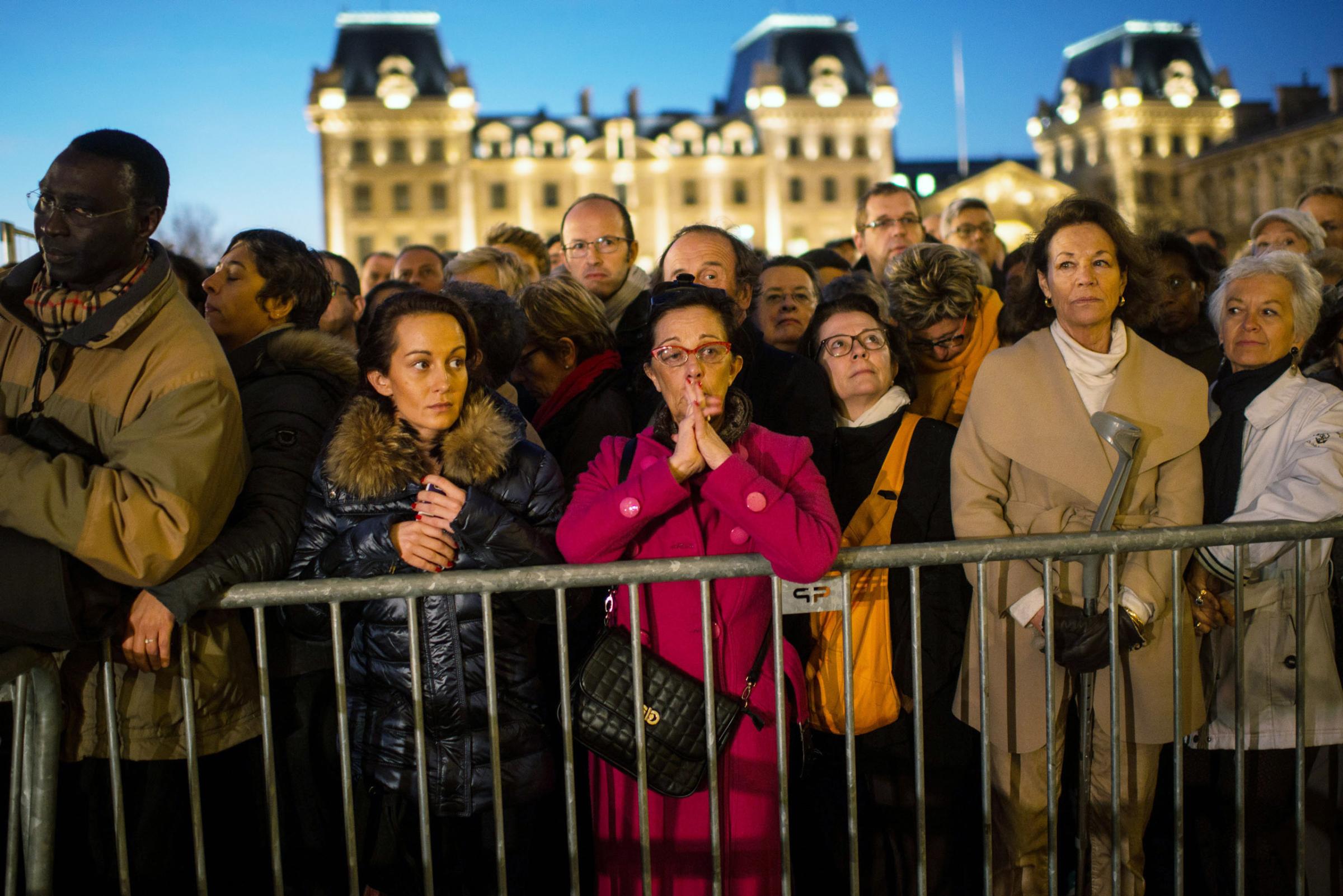 PARIS, FRANCE - NOVEMBER 15: People gather outside of Notre Dame cathedral ahead of a ceremony to the victims of friday's terrorist attacks on November 15, 2015 in Paris, France. As France observes three days of national mourning members of the public continue to pay tribute to the victims of Friday's deadly attacks. A special service for the families of the victims and survivors is to be held at Paris's Notre Dame Cathedral later on Sunday. (Photo by David Ramos/Getty Images)