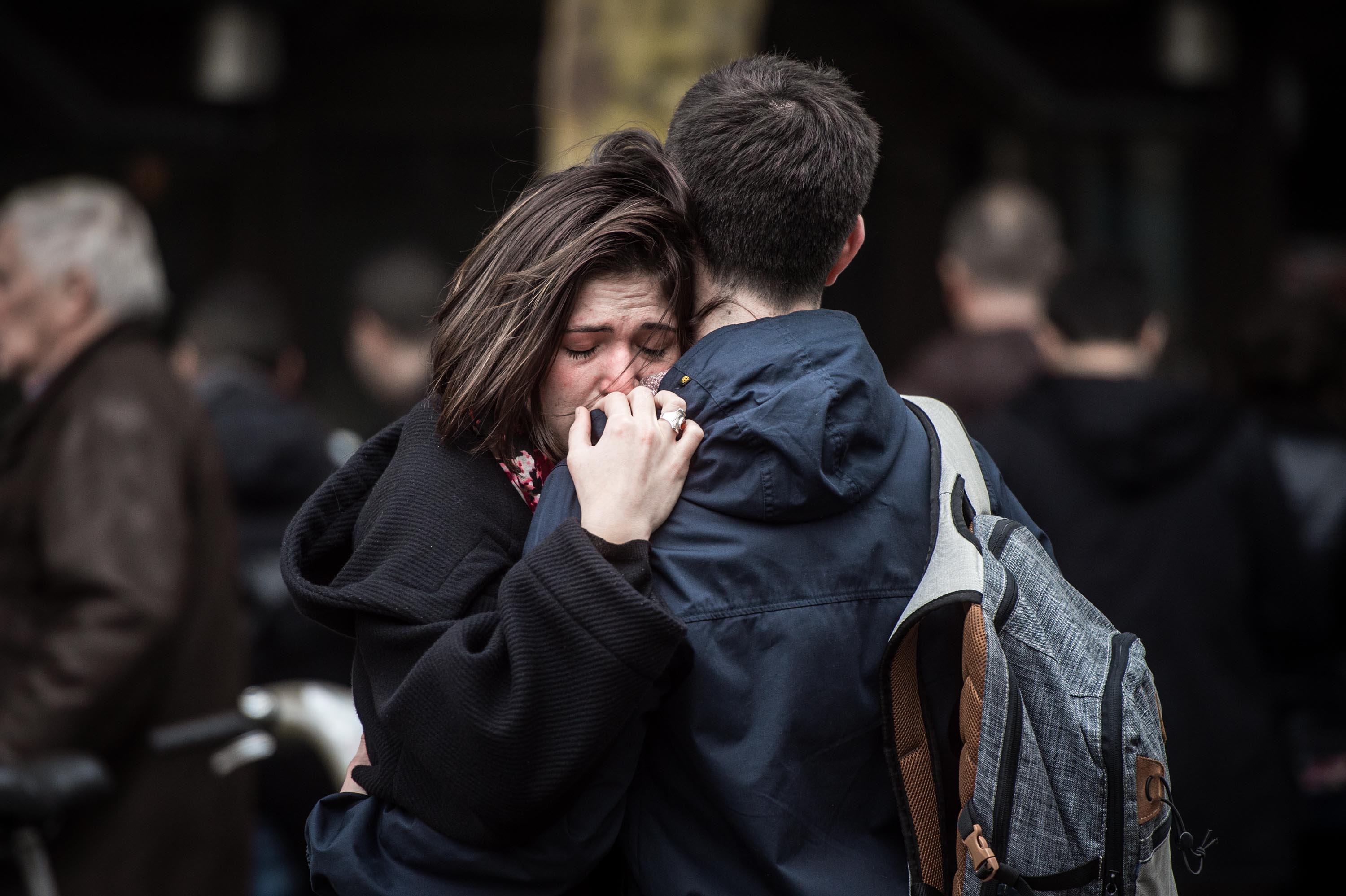 A couple embrace near the Cosa Nostra restaurant in Paris on Nov. 14, 2015. (David Ramos—Getty Images)