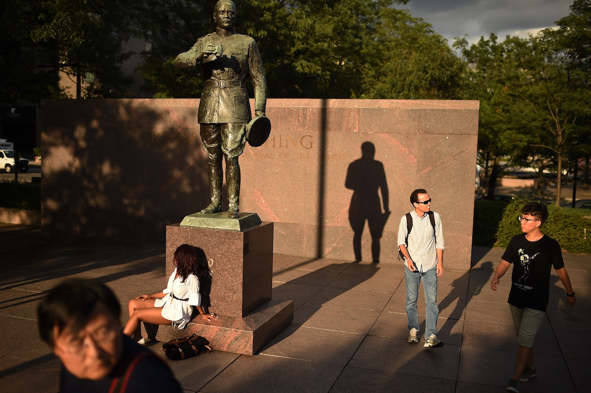 People are seen near a statue of John J. Pershing in Pershing Park on Aug. 03, 2014, in Washington, DC. (The Washington Post / Getty Images)