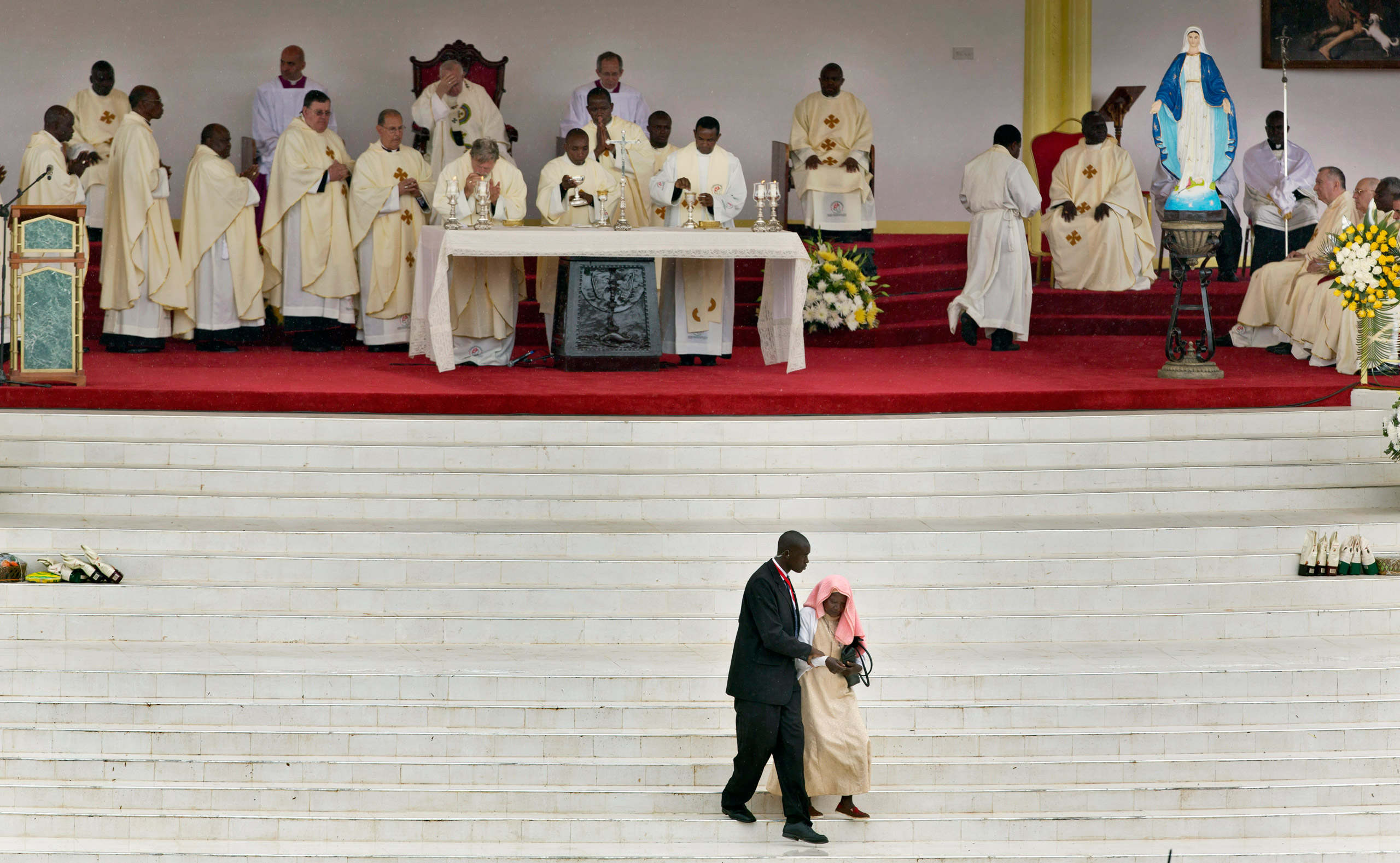 A security guard escorts a nun away after she tried to walk up the steps from the crowd to the altar as Pope Francis held a Mass at the campus of the University of Nairobi on Nov. 26, 2015.