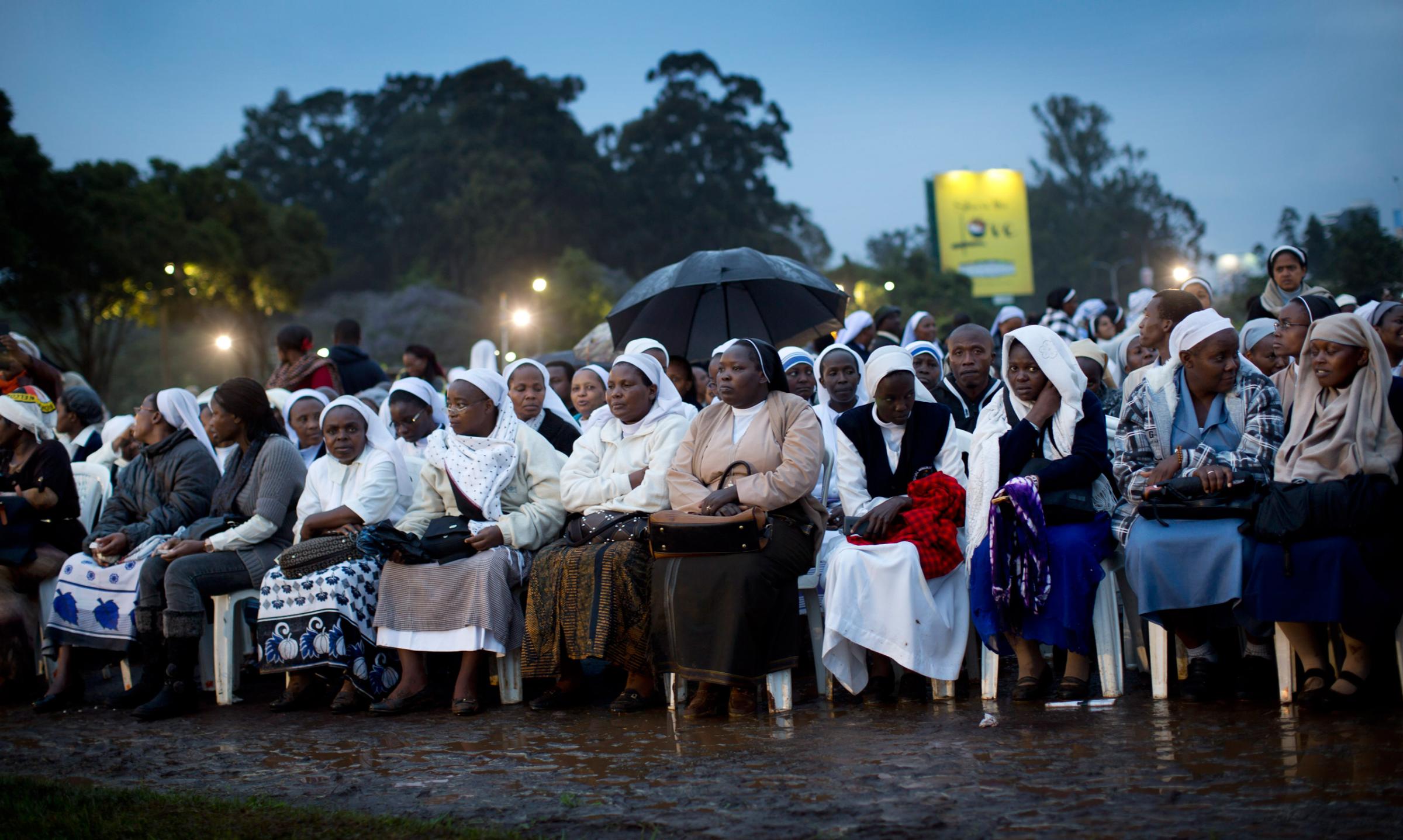 Catholic sisters wait just after dawn in the rain and mud to attend a Mass to be given by Pope Francis at the campus of the University of Nairobi in Kenya Thursday, Nov. 26, 2015. Pope Francis is in Kenya on his first-ever trip to Africa, a six-day pilgrimage that will also take him to Uganda and the Central African Republic. (AP Photo/Ben Curtis)