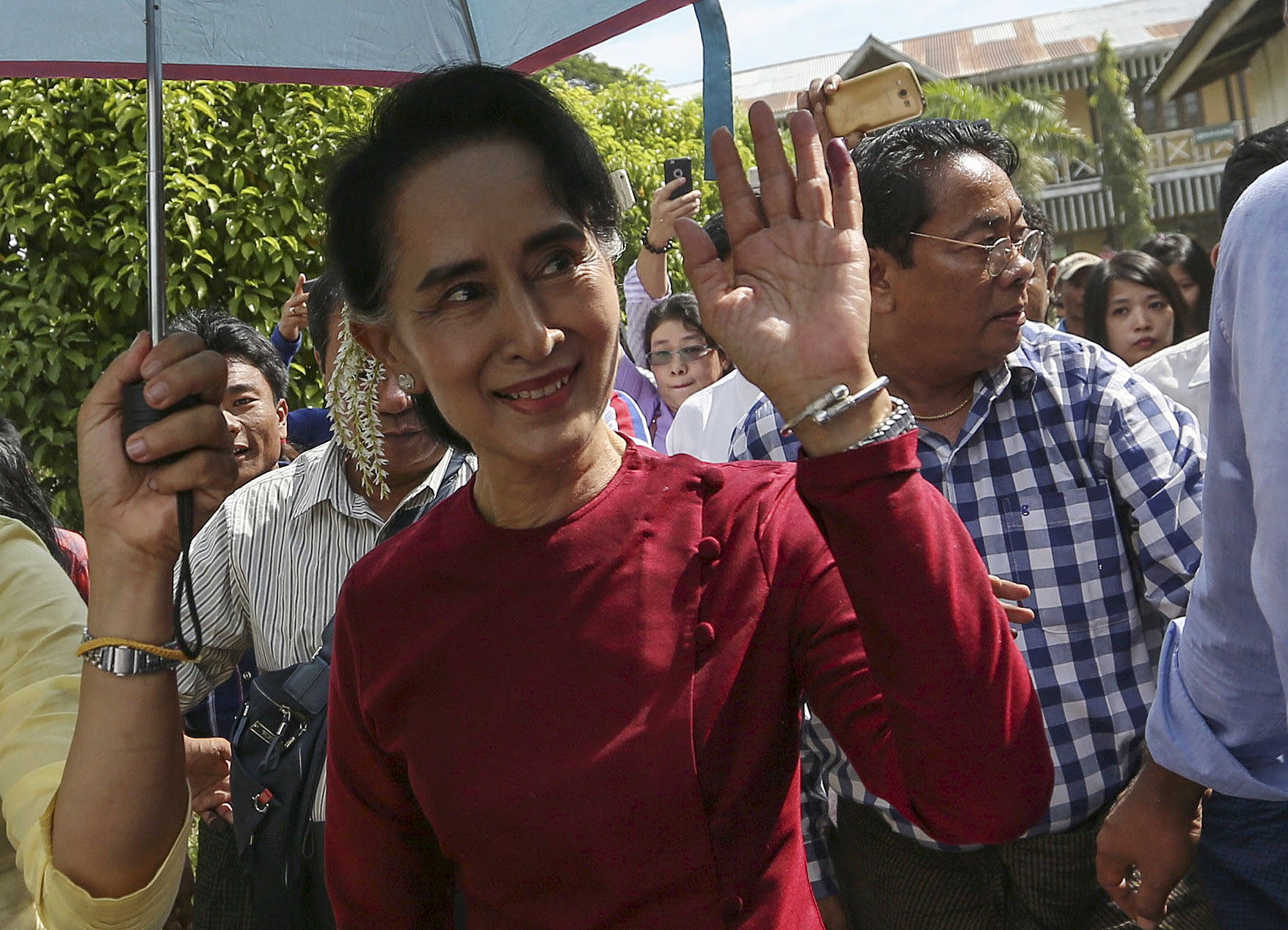 Myanmar pro-democracy leader Aung San Suu Kyi waves at supporters as she visits polling stations at her constituency Kawhmu township