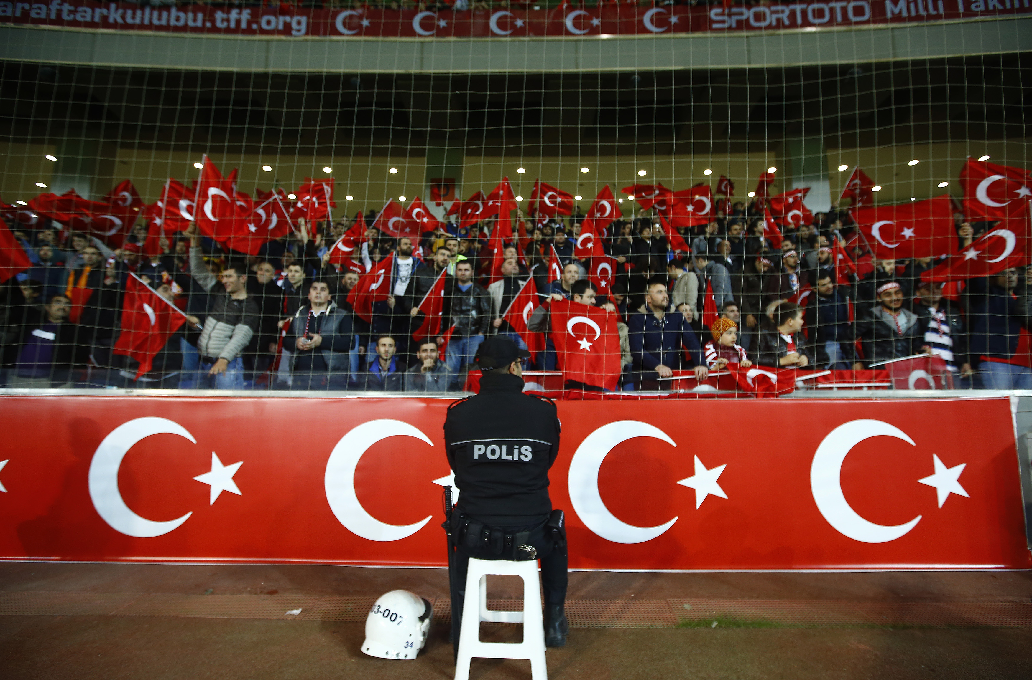 A policeman stands guard in front of supporters of Turkey during their international friendly soccer match against Greece at Basaksehir Fatih Terim Stadium in Istanbul on Nov. 17, 2015 (Osman Orsal—Reuters)