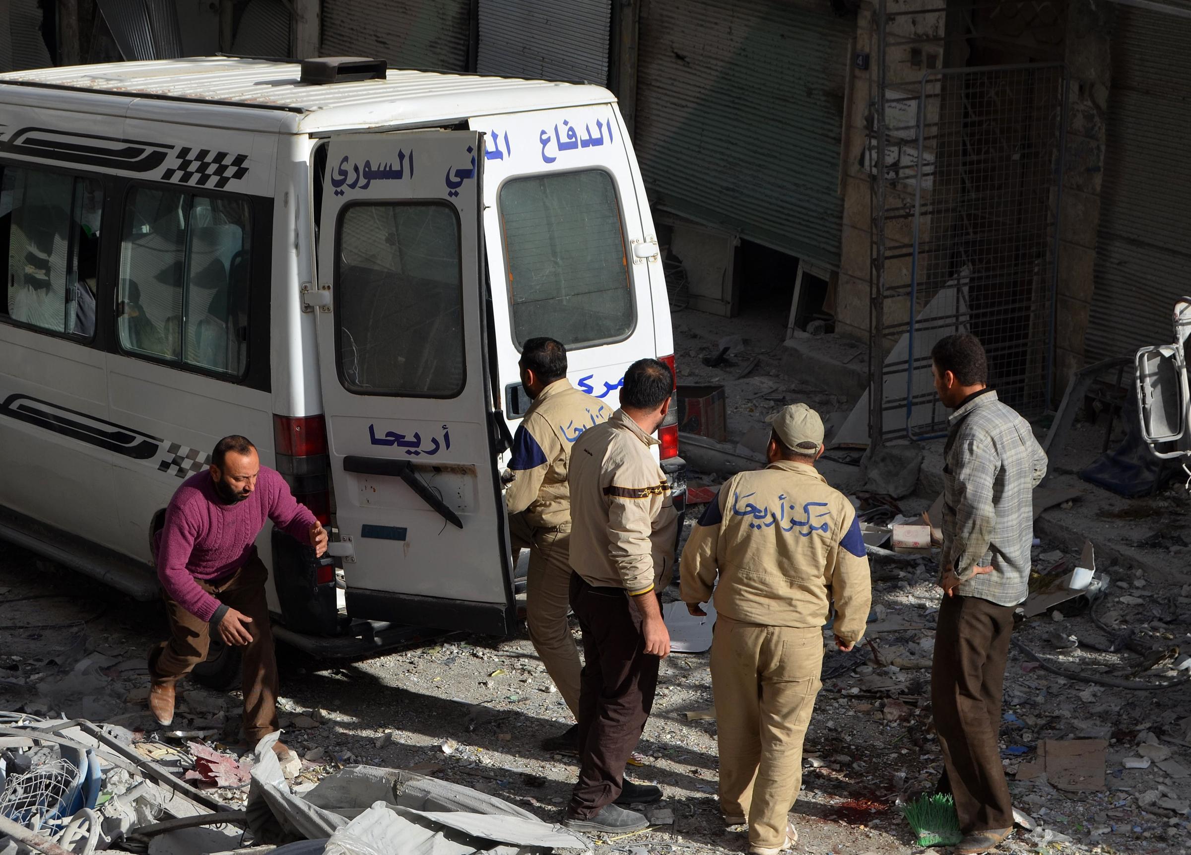 Syrian civil defense members carry a wounded man into an ambulance following the Russian airstrikes targeting a market and residential area in Ariha town Idlib, northern Syria on Nov. 29, 2015.