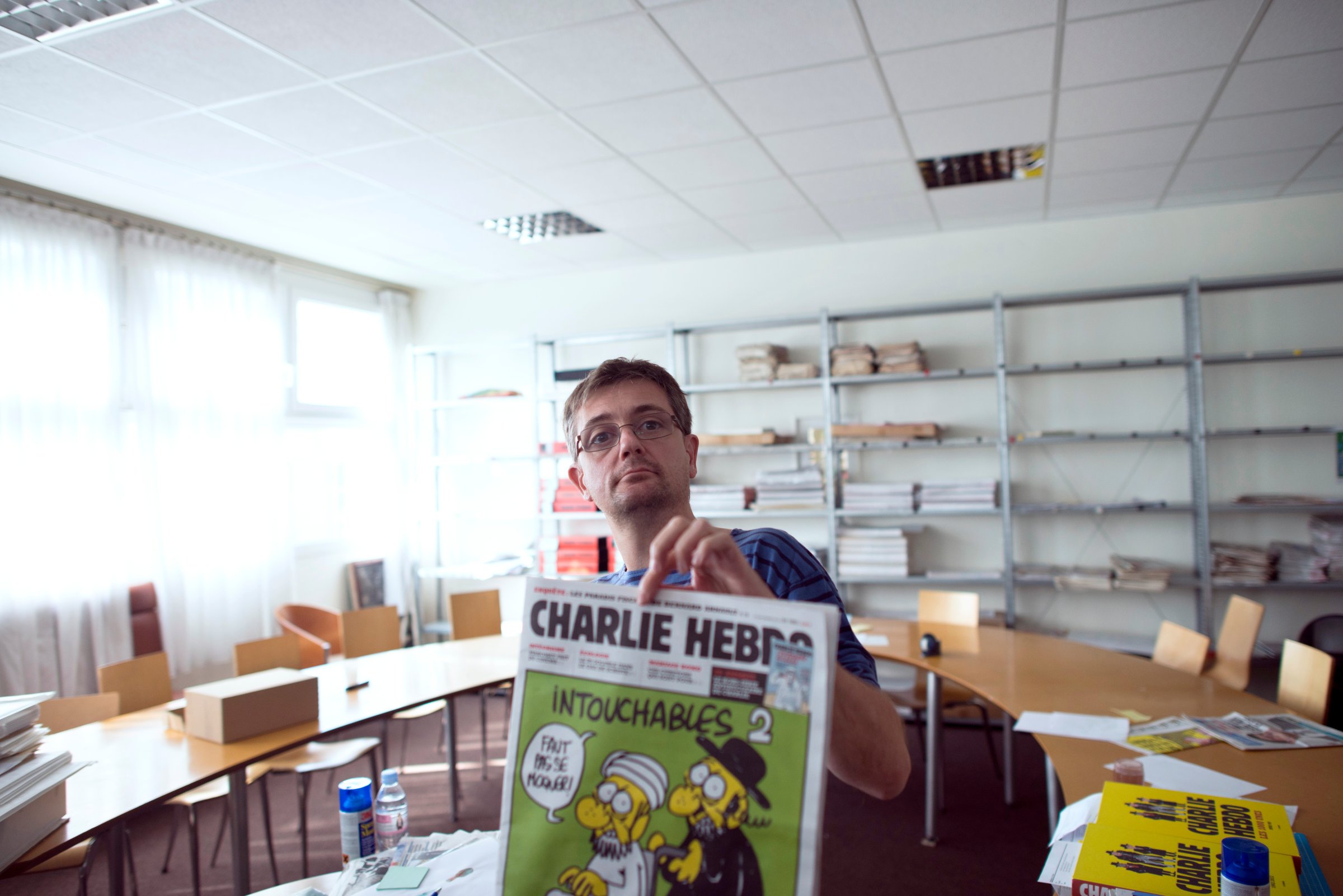 French satirical weekly Charlie Hebdo's publisher and cartoonist presents to journalists the last issue which features on the front cover a satirical drawing titled "Intouchables 2" in Paris on Sep. 19, 2012.