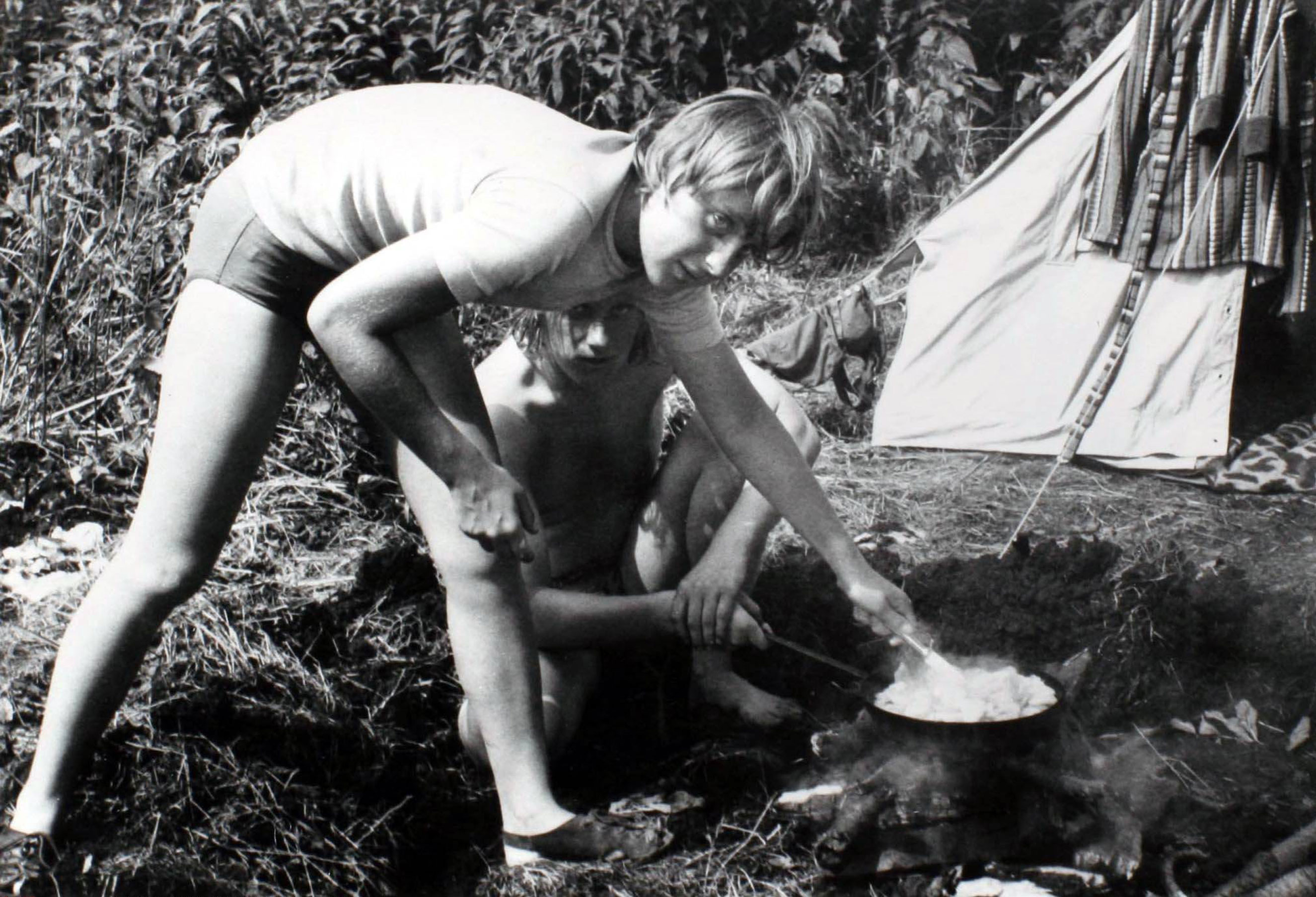 Angela Kasner prepares a meal on a campfire while camping with friends in Himmelpfort, German Democratic Republic on July 1973.