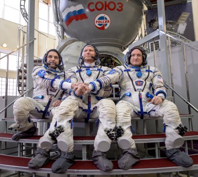 Russian cosmonaut Mikhail Kornienko of the Russian Federal Space Agency, Russian cosmonaut Gennady Padalka of Roscosmos and NASA Astronaut Scott Kelly pose outside a Soyuz simulator during the second day of qualification exams at the Gagarin Cosmonaut Training Center in Star City, Russia on March 5, 2015.