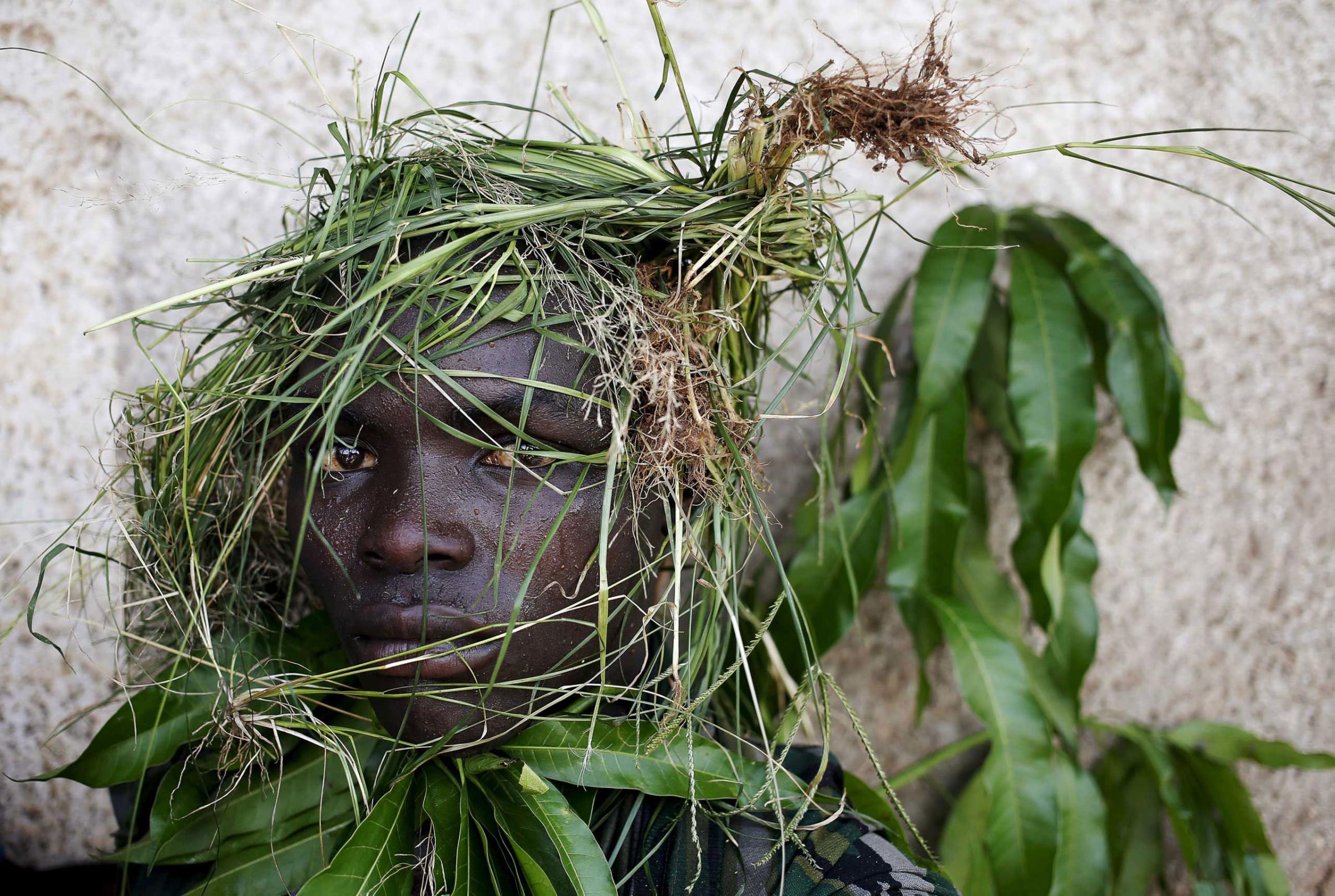 A protester wears grass around his face to obscure his identity during a protest against President Pierre Nkurunziza's decision to run for a third term, in Bujumbura, Burundi.
