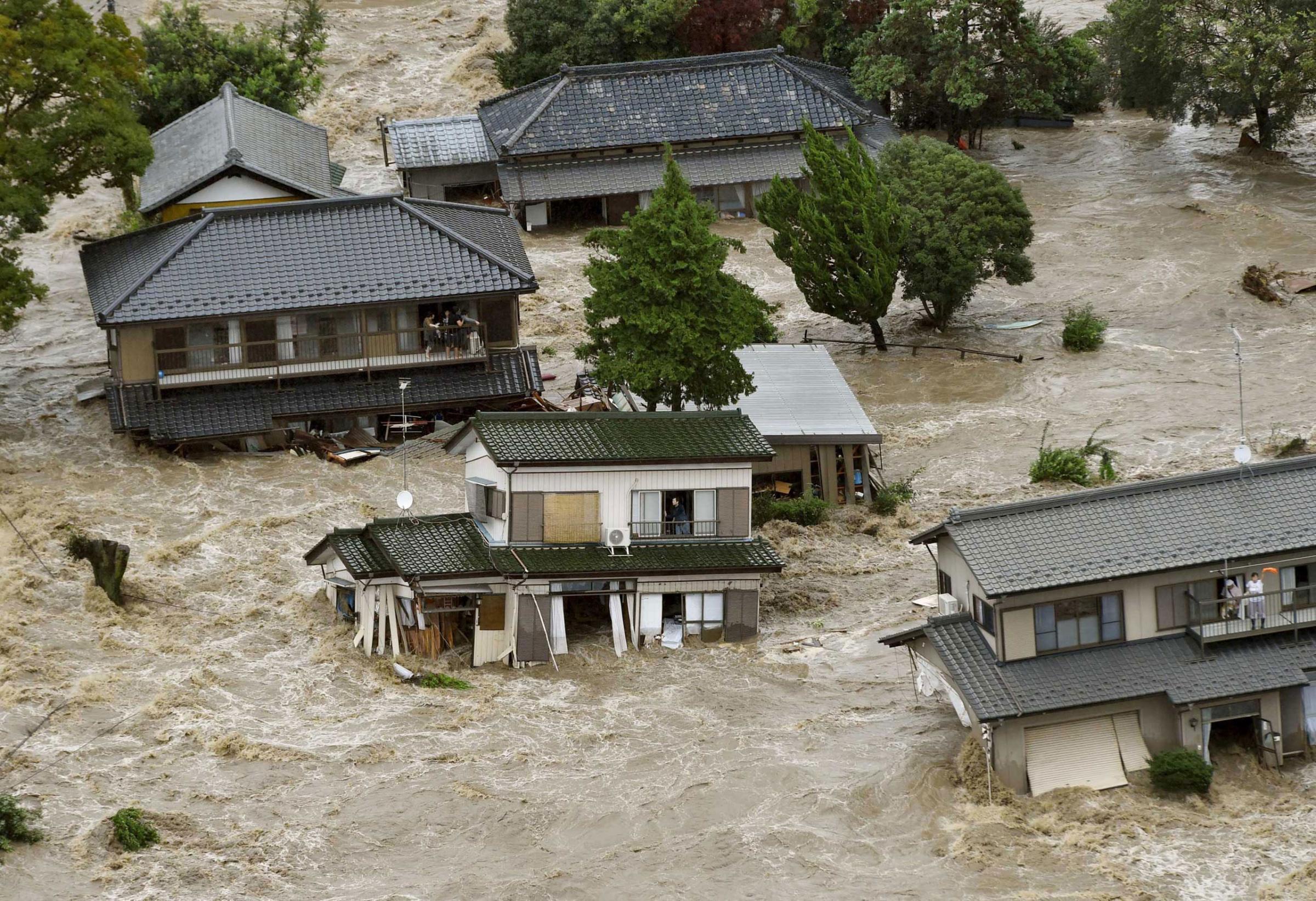 Residents wait for rescue helicopters at a flooded residential area as the Kinugawa river burst their banks, caused by typhoon Etau, in Joso, Ibaraki prefecture, Japan. Sept. 10, 2015.