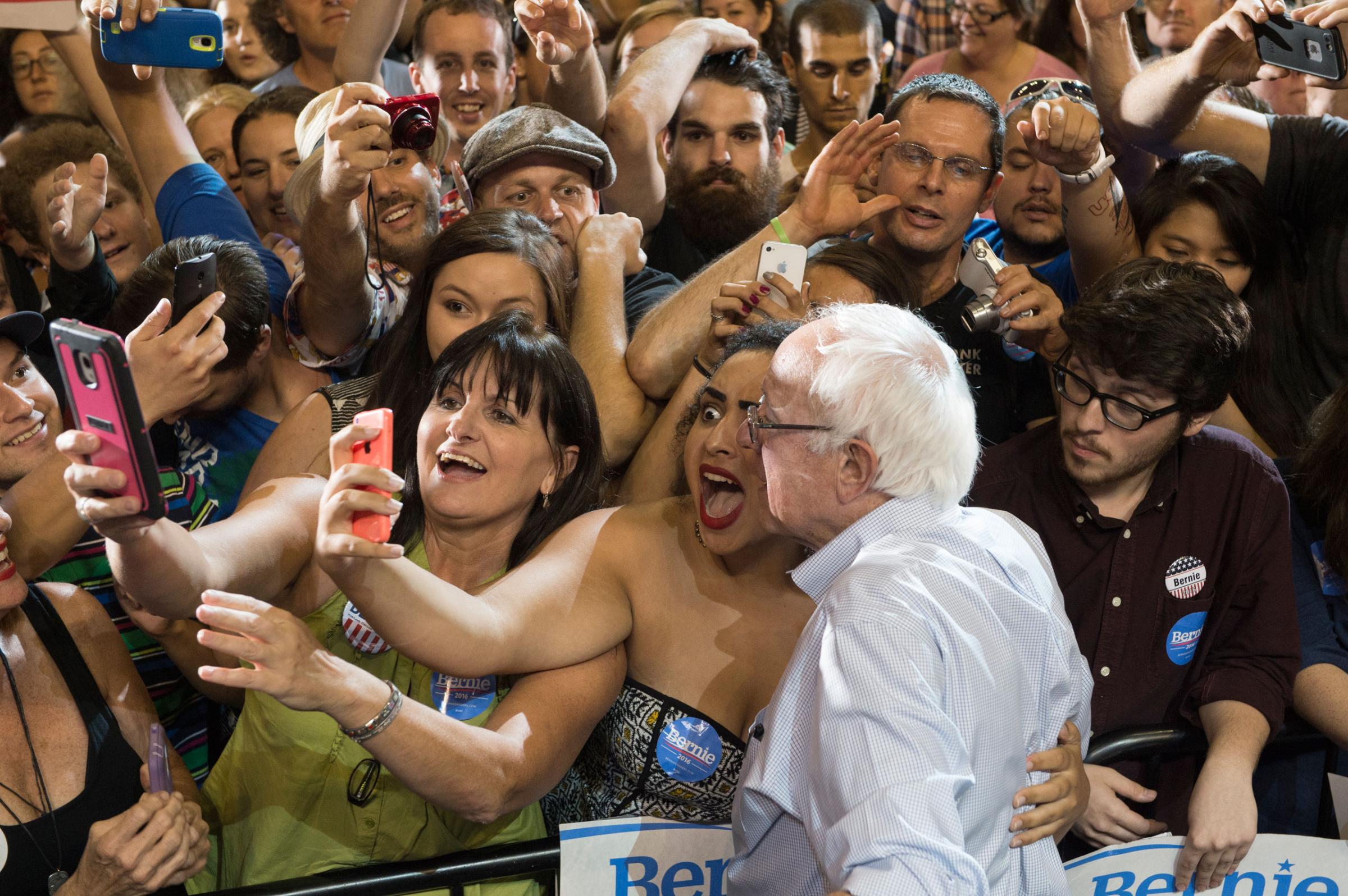 Naomi Scott, center, of McMinnville, Ore., takes a picture with Democratic presidential candidate Senator Bernie Sanders, I-Vt., at a rally at the Moda Center in Portland, Ore. Aug. 9, 2015.