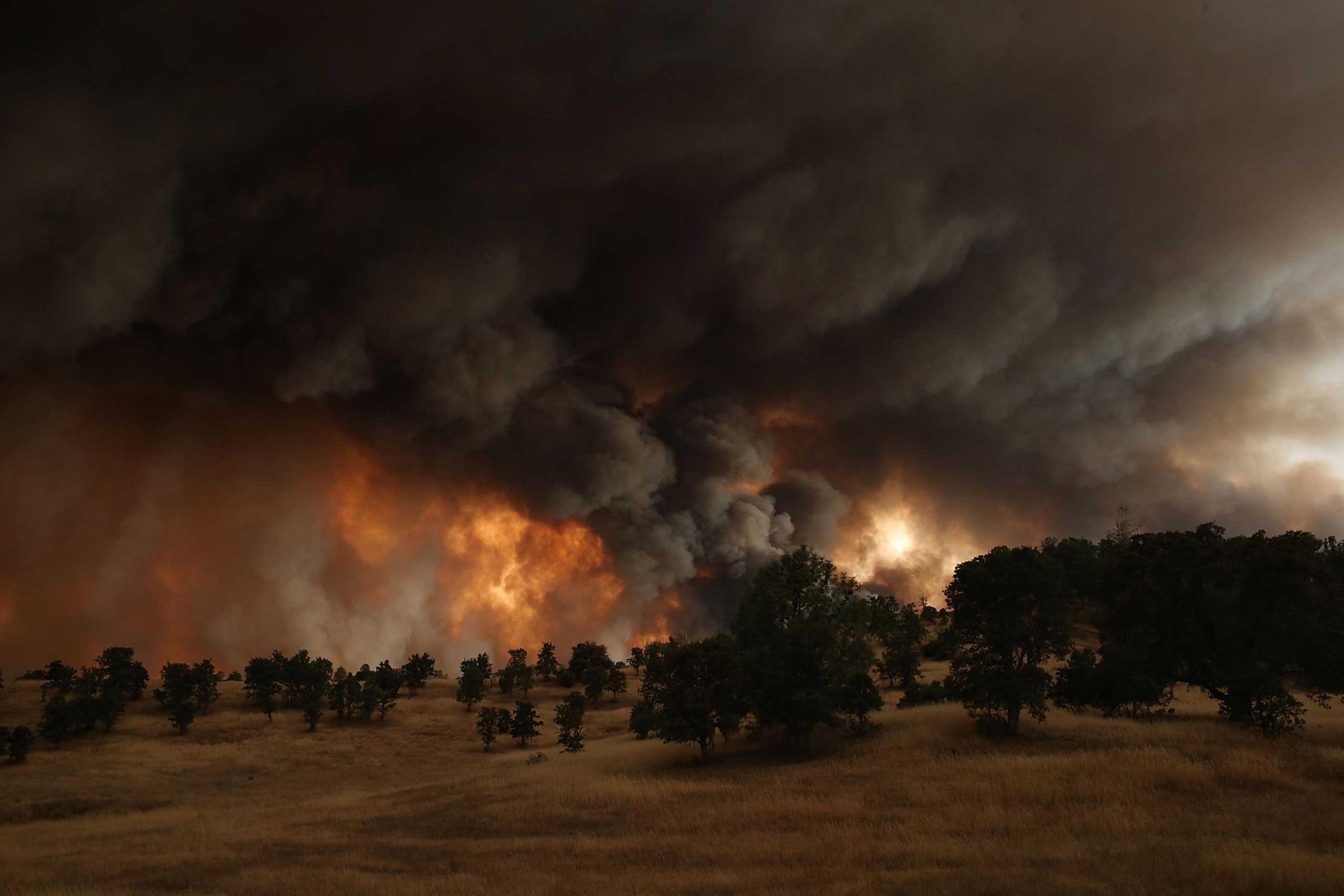 A large plume of smoke rises from the Rocky Fire near Clearlake, California. Over 1,900 firefighters are battling the Rocky Fire that burned over 22,000 acres since it started earlier that week. The fire is currently five percent contained and has destroyed at least 14 homes. Aug. 1, 2015