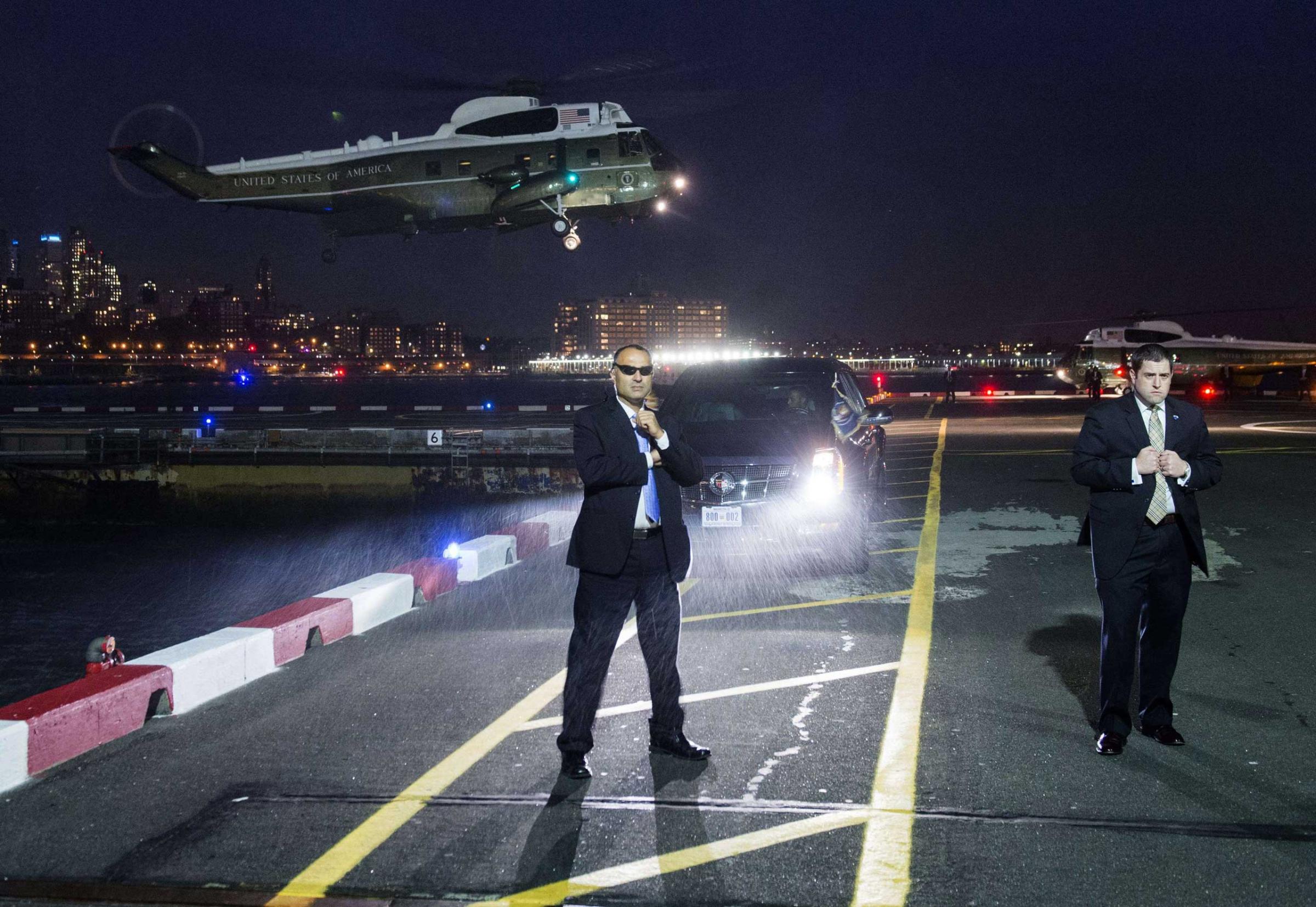 U.S. Secret Service Agents stand guard as Marine One, with U.S. President Barack Obama on board, prepares to land at the Downtown Manhattan Heliport in New York City. President Obama is traveling to attend Democratic fundraisers. Nov. 2, 2015
