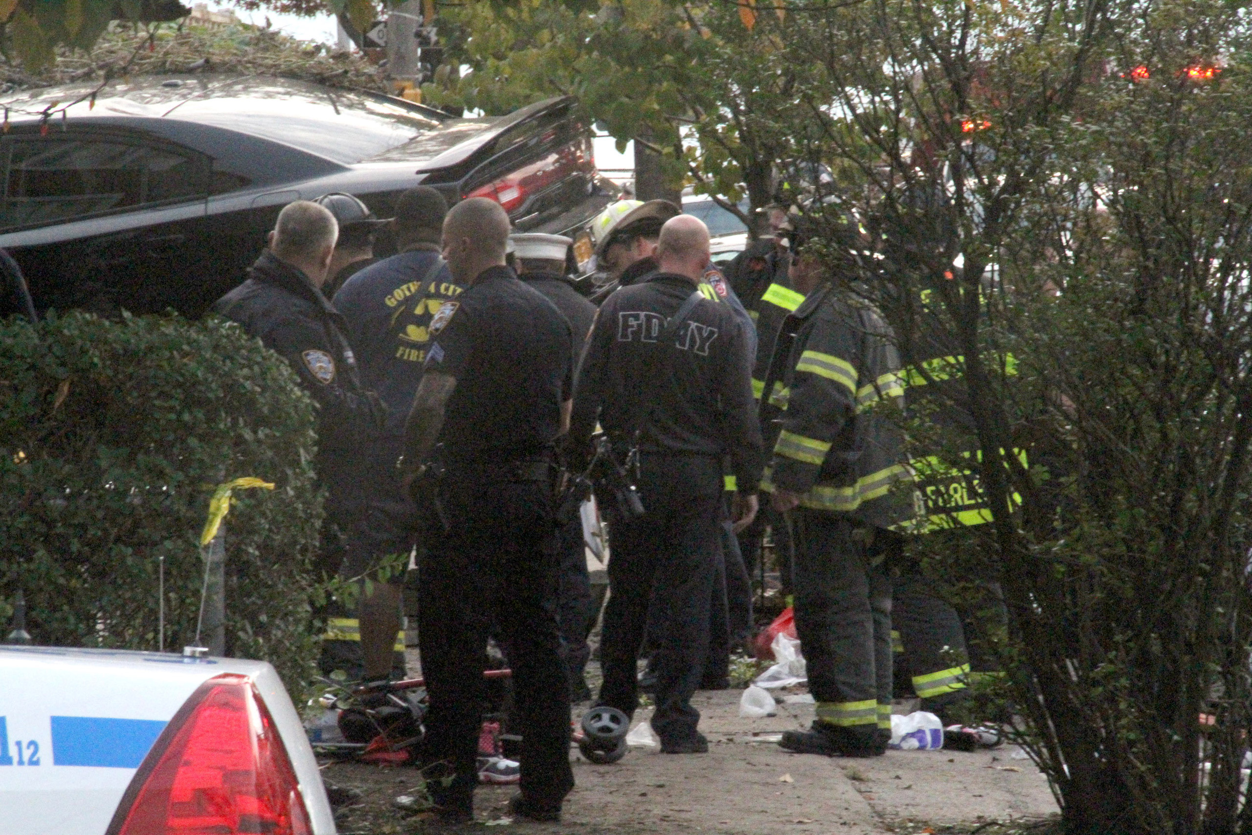 First responders examine an automobile after its driver lost control and plowed into a group of trick-or-treaters, killing three people and injuring several, in the Bronx, N.Y., on Oct. 31, 2015. (David Greene—AP)