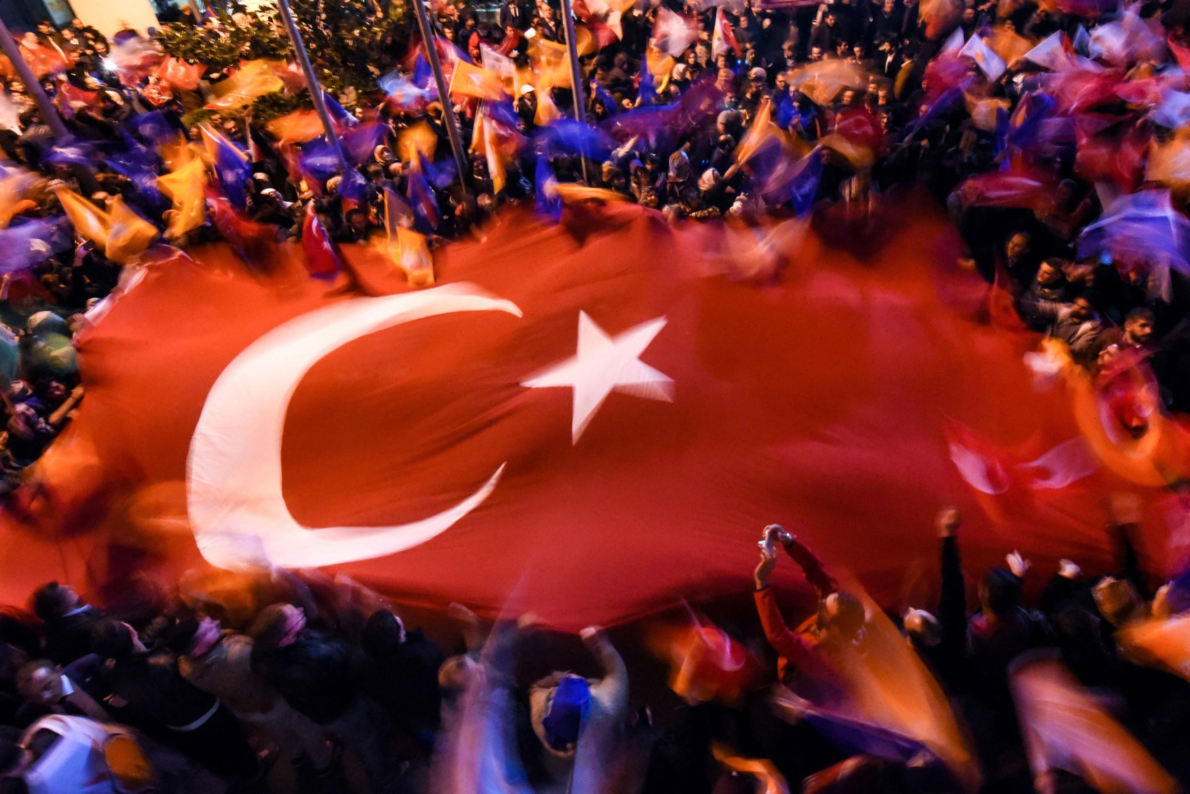 Supporters of Turkey's Justice and Development Party (AKP) wave a giant Turkish flag as they celebrate in Istanbul after the first results in the country's general election on November 1, 2015. Turkey's long-dominant Justice and Development Party (AKP) scored a stunning electoral comeback, regaining its parliamentary majority in a poll seen as crucial for the future of the troubled country. AFP PHOTO / OZAN KOSEOZAN KOSE/AFP/Getty Images