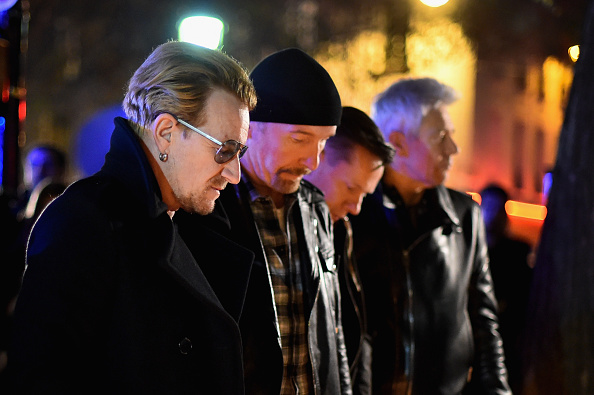 Bono and band members of U2 pay their respects and place flowers on the pavement near the scene of the Bataclan Theatre terrorist attack on November 14, 2015 in Paris, France.