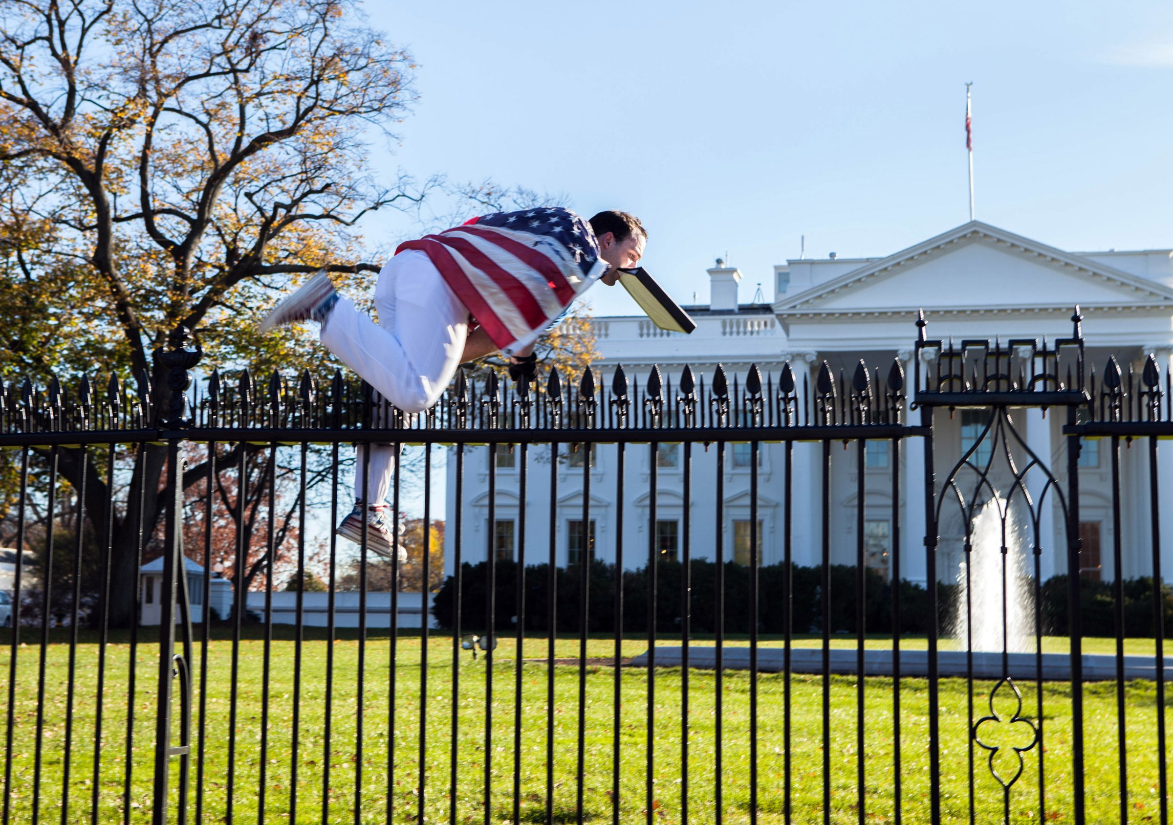 In this photo provided by Vanessa Pena, a man jumps a fence at the White House on Thursday, Nov. 26, 2015, in Washington. The man was immediately apprehended and taken into custody pending criminal charges, the Secret Service said. President Barack Obama and his wife and daughters were spending Thanksgiving the holiday at the White House. (Vanessa Pena via AP) MANDATORY CREDIT