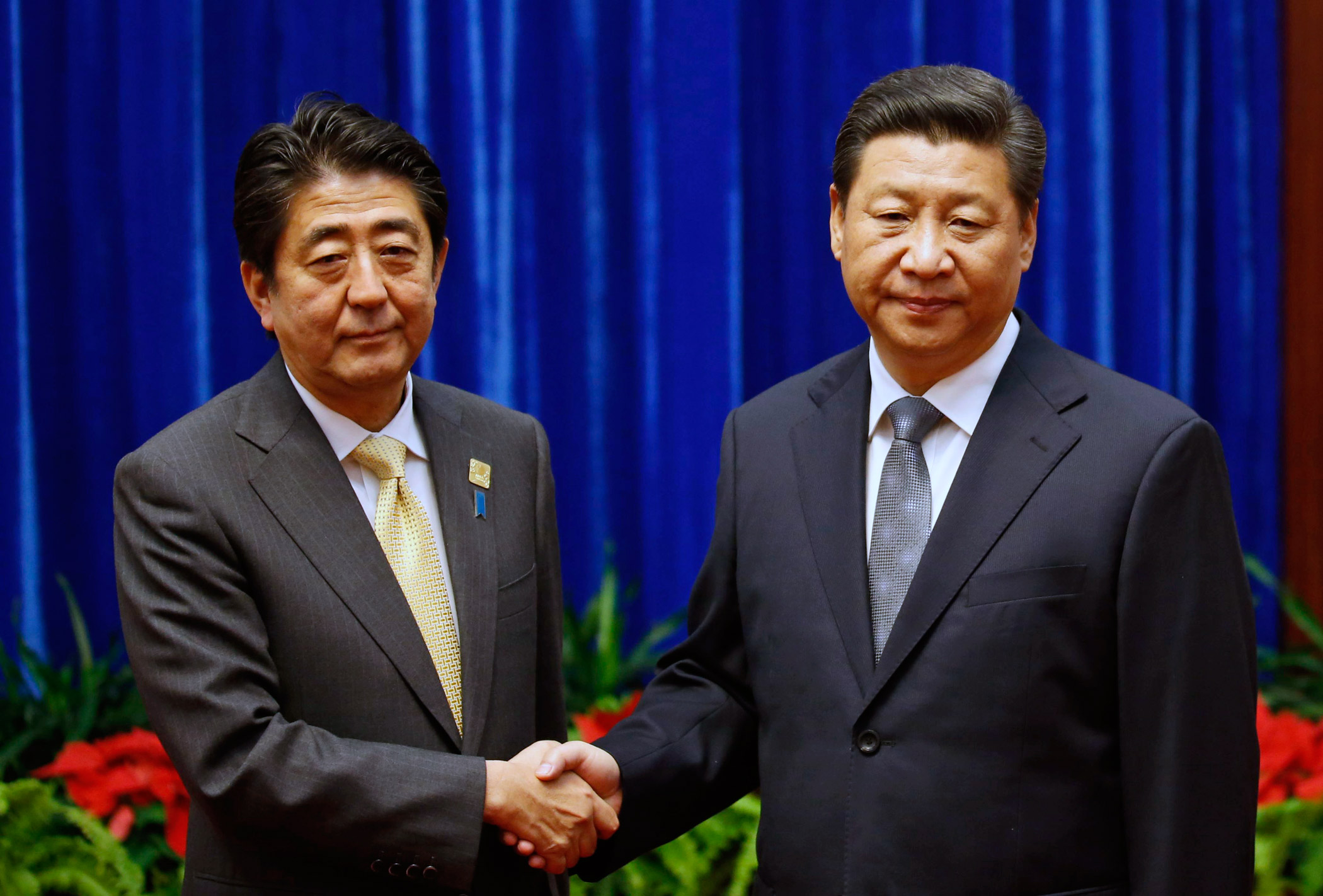 Chinese President Xi Jinping, right, shakes hands with Japanese Prime Minister Shinzo Abe, during their meeting on the sidelines of the Asia Pacific Economic Cooperation (APEC) meetings on Nov. 10, 2014 in Beijing.