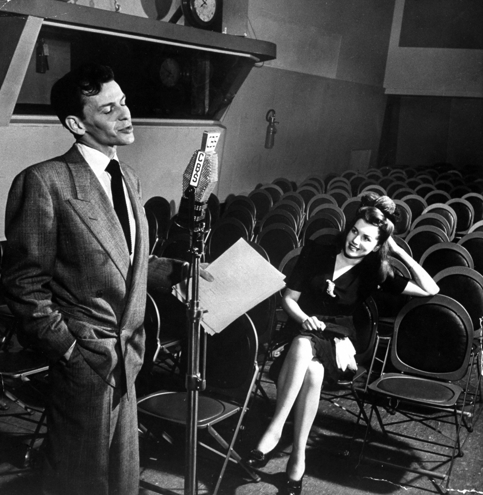 Frank Sinatra singing Close to You in CBS radio broadcasting studio as his admirer Rita Stearns, the winner of the Why I Like Frank Sinatra contest, looks on, in the audience, 1944.