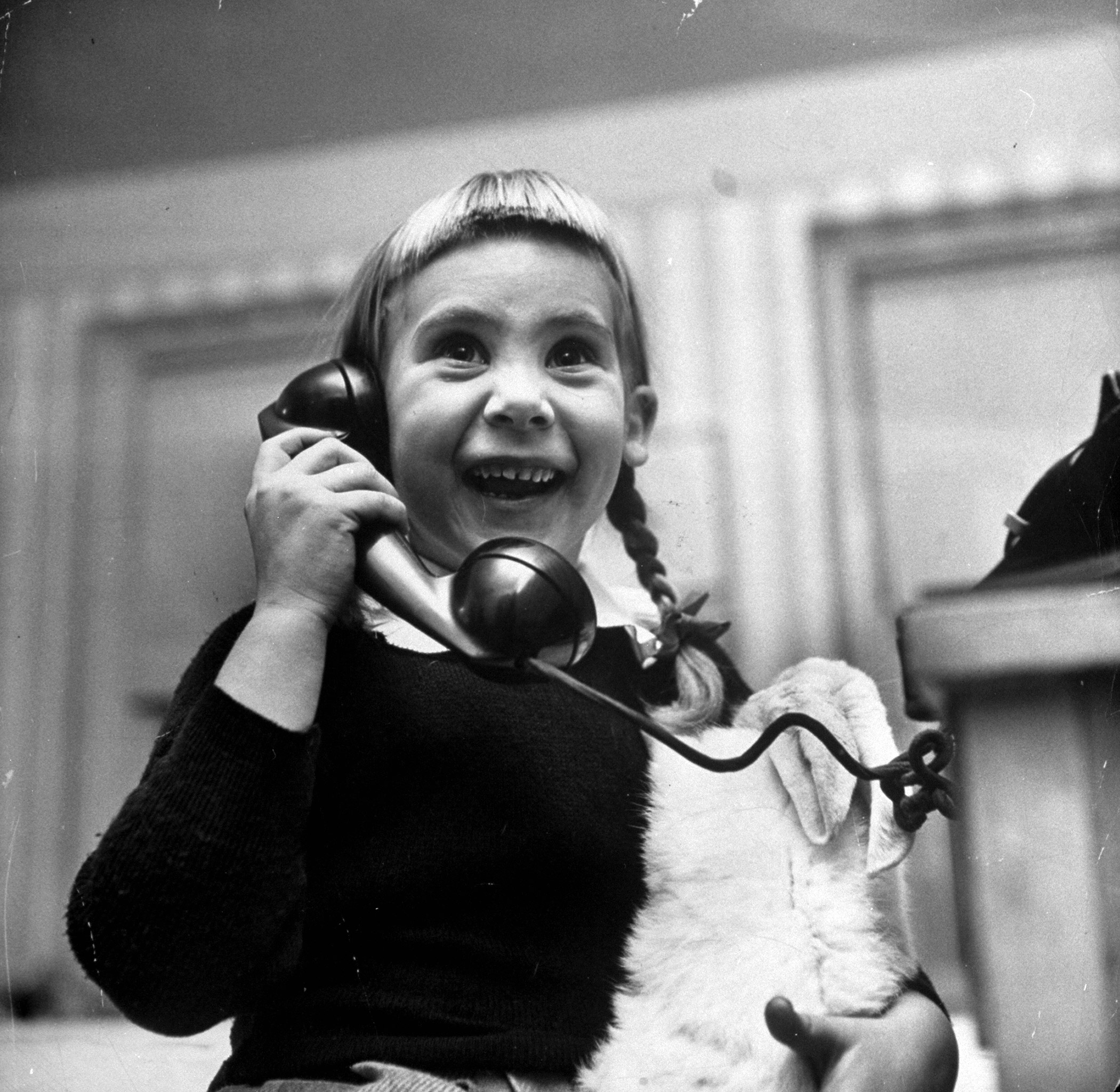 A young girl talking to Santa Claus on the telephone, 1947.