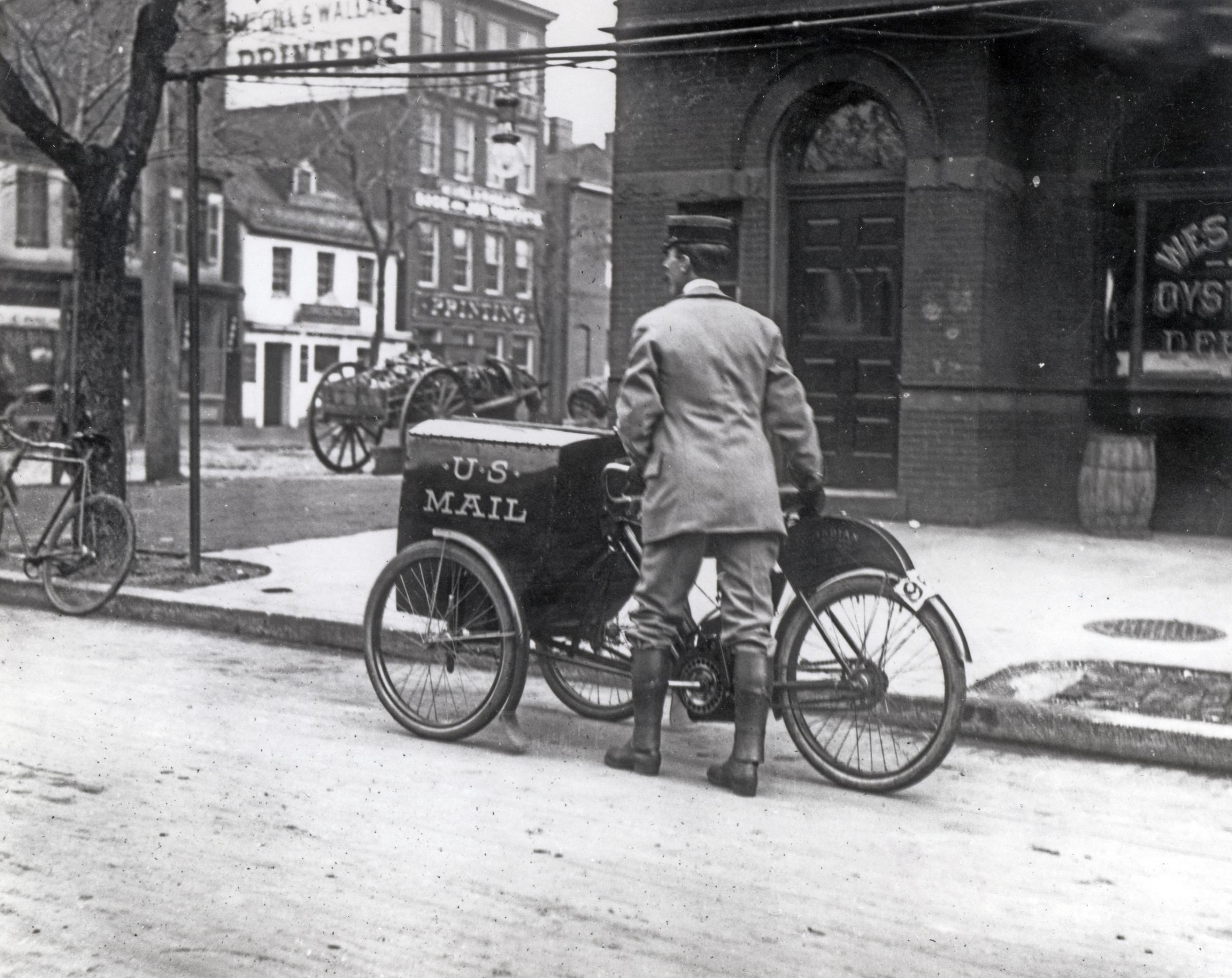 Three-wheeled mail collection Indian motorcycle in Washington, D.C., on the corner of Pennsylvania Avenue and 12th Street. The motorcycle was used only on an experimental basis in DC. 1912.