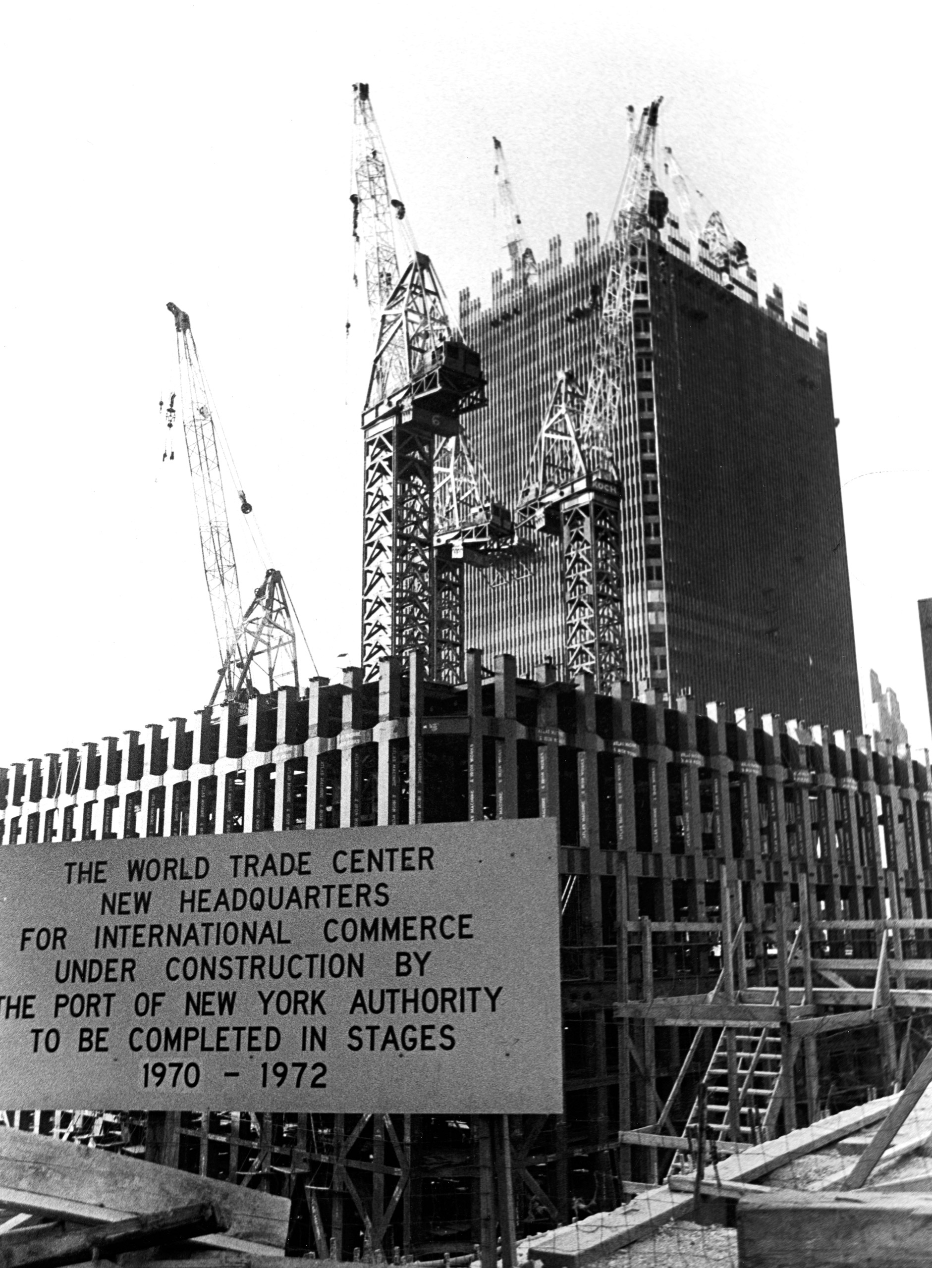 View of the World Trade Center under construction, with a sign announcing the completion schedule, circa 1969, New York City,
