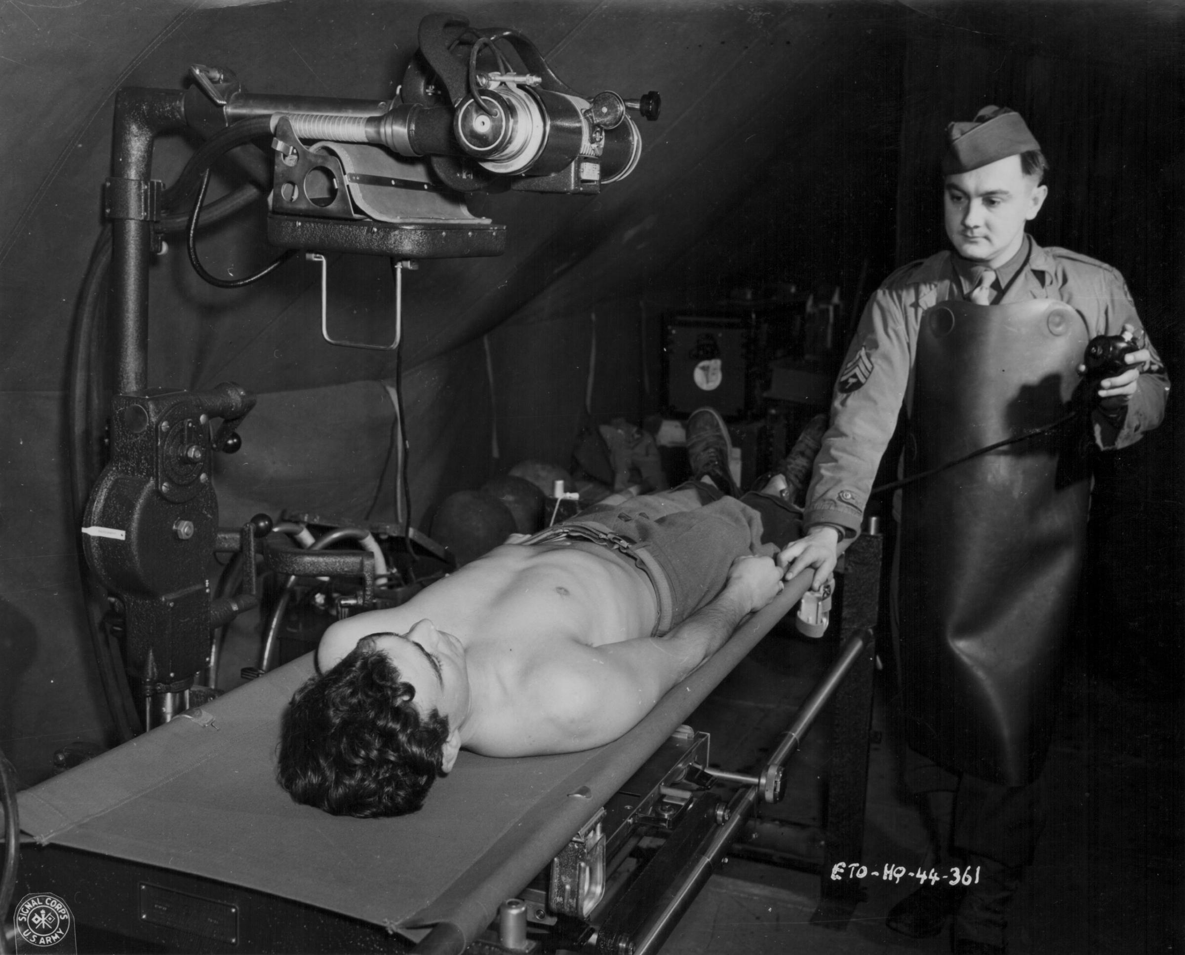 An x-ray technician with the US Medical Corps tending to a wounded soldier during World War Two, circa 1941-1945.