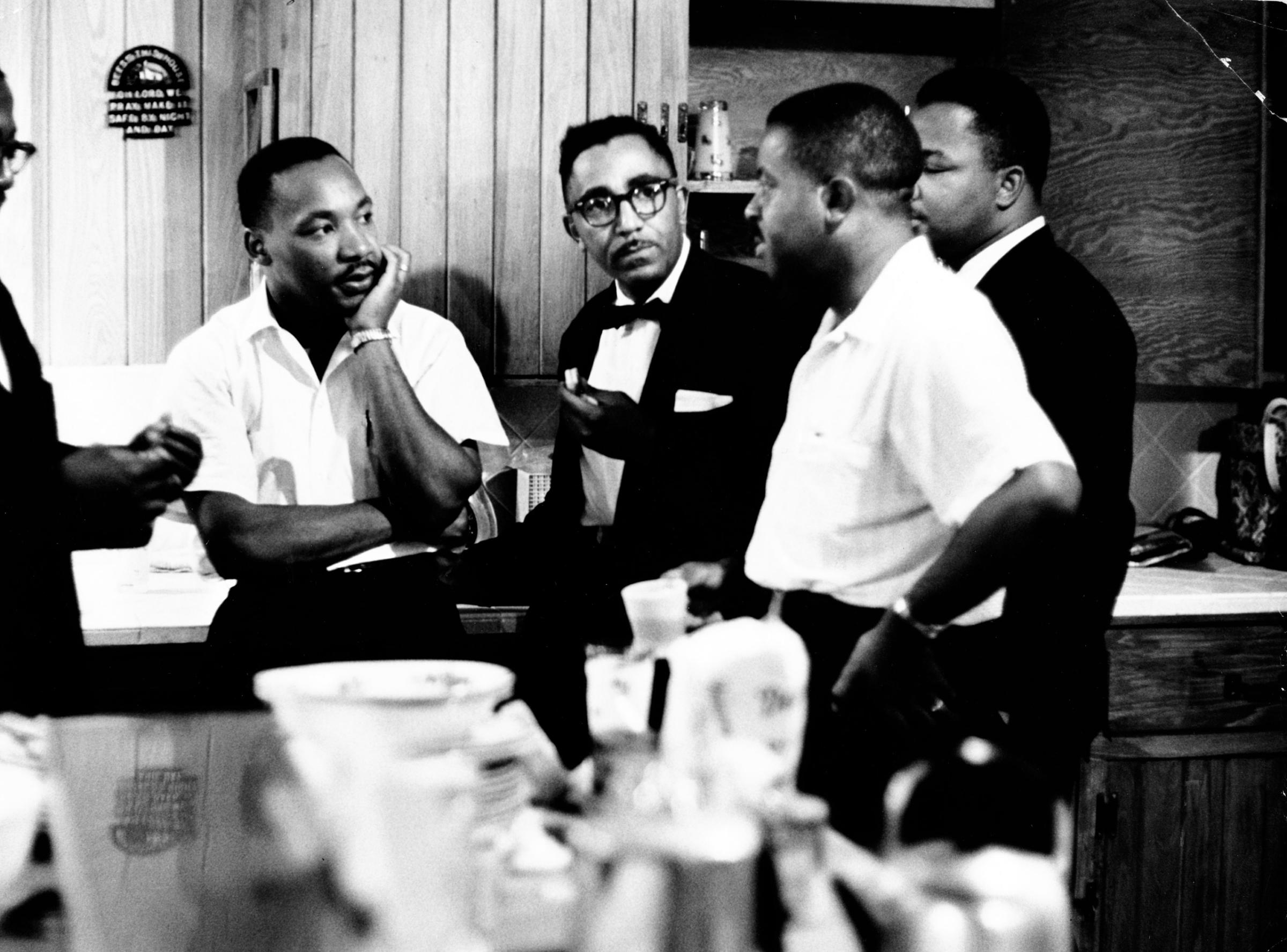 Rev. Martin Luther King Jr. (C) speaking with Rev. Ralph Abernathy (2nd R) and others, 1961.
