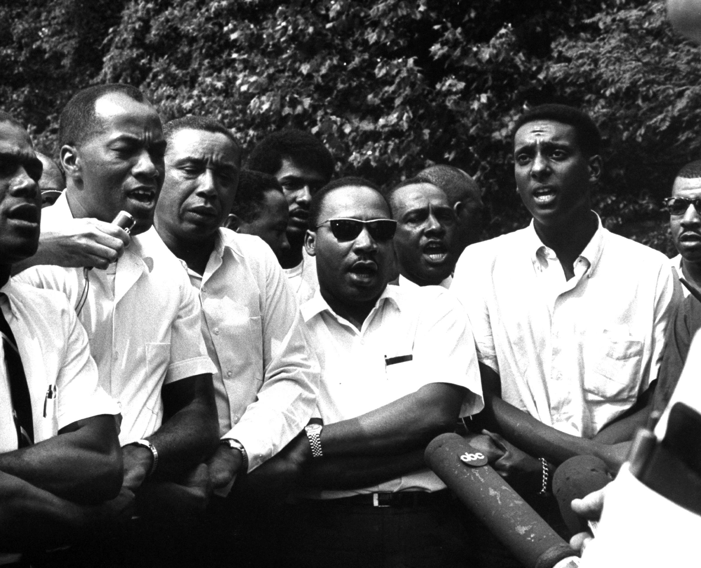Civil rights leaders Floyd B. McKissick (fore, 3L), Dr. Martin Luther King Jr. (4R) and Stokely Carmichael (2R) participating in voter registration march after originator James H. Meredith was shot, 1966.
