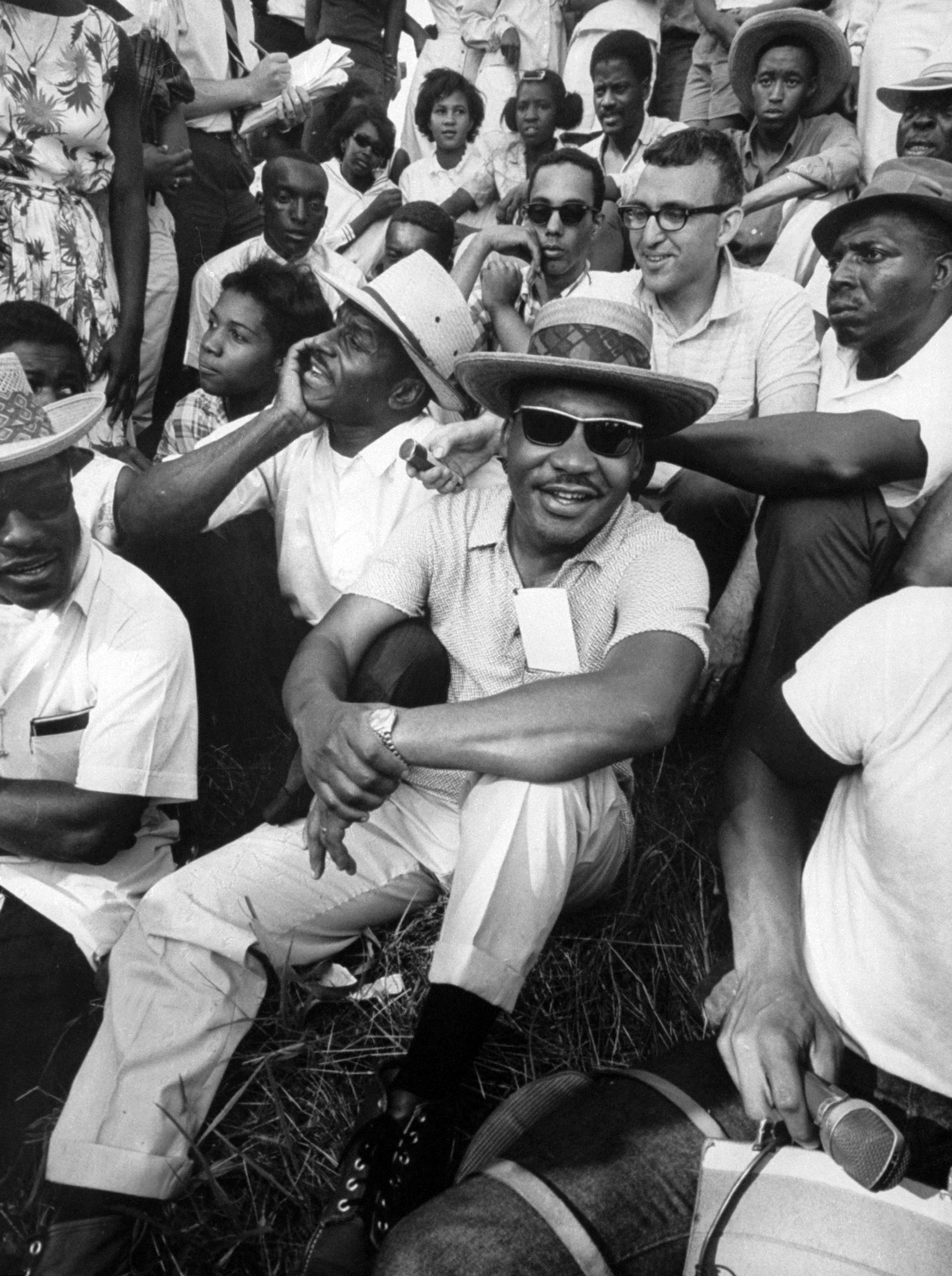 Civil rights leader Dr. Martin Luther King Jr. sitting with demonstrators who walked through Mississippi to encourage voter registration., 1966.