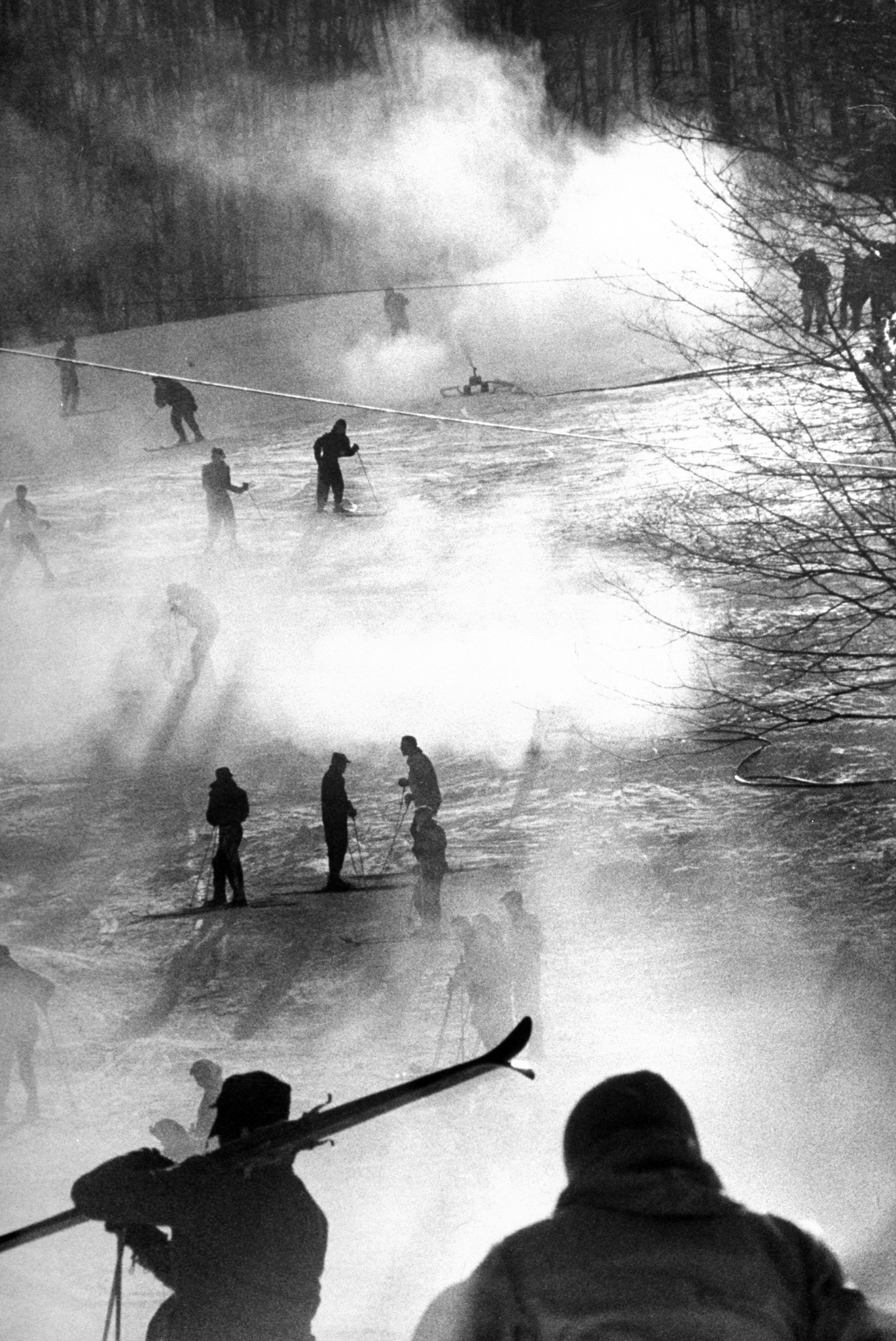 Manufactured snow, blowing from nozzles, veils skiers in mists at Bousquet's, near Pittsfield Mass. During a January thaw, Bousquet's was jammed with skiers unable to ski elsewhere. The artificial powdery surface, made from compressed air and water, can be laid at temperature below 32 degrees.
