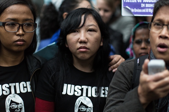 Former Indonesian domestic helper Erwiana Sulistyaningsih, center, looks on as a supporter, right, speaks to the press in front of the District Court following the sentencing of her former employer Law Wan-tung in Hong Kong on Feb. 27, 2015 (Anthony Wallace—AFP/Getty Images)