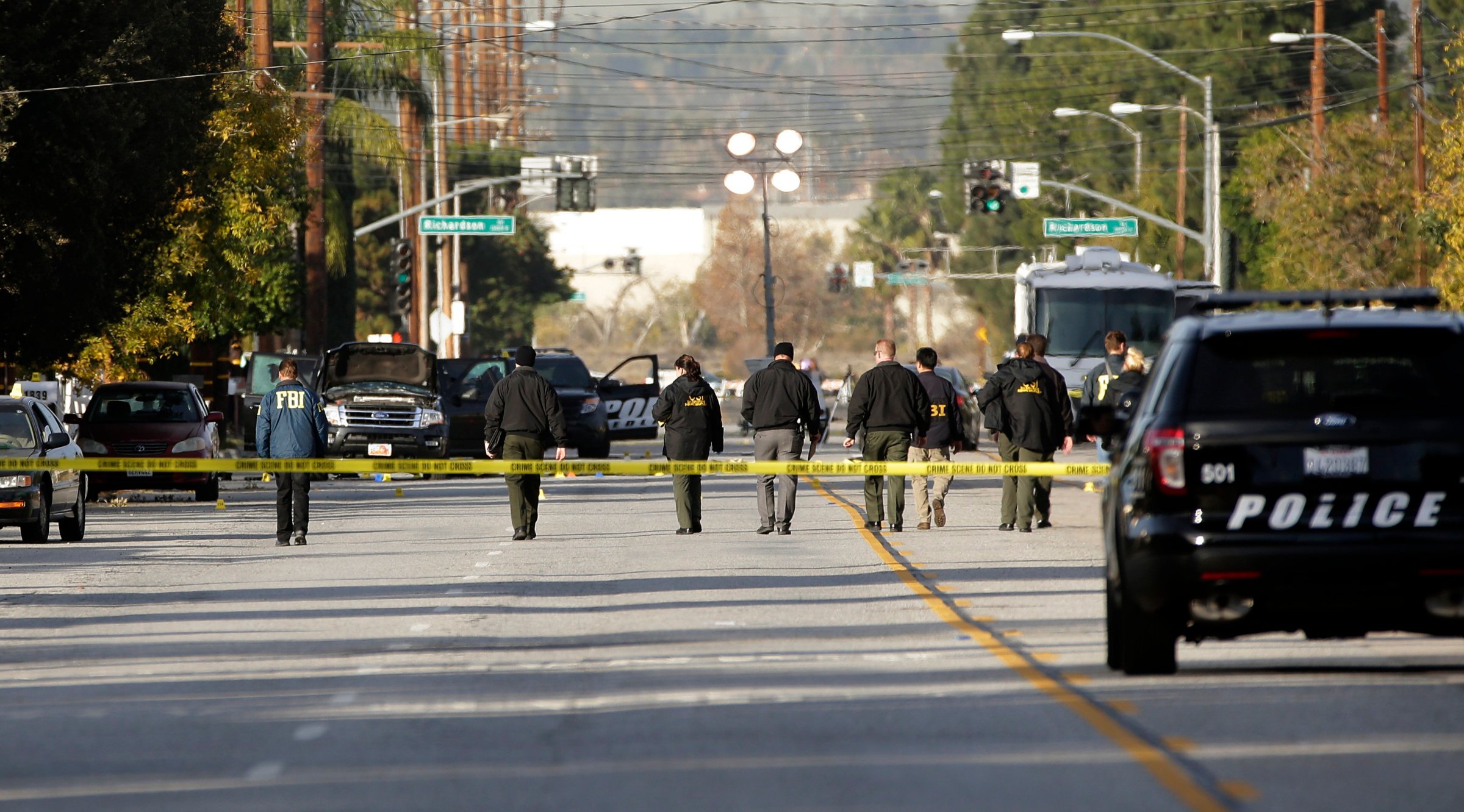 Investigators search for bullet casings at the scene where Wednesday's police shootout with suspects took place in San Bernardino, Calif on Dec. 3, 2015.