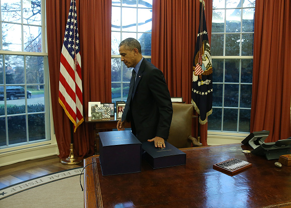 US President Barack Obama gets up from his desk after signing the budget bill that will fund the government until next September, in the Oval Office at the White House December 18, 2015 in Washington, DC.