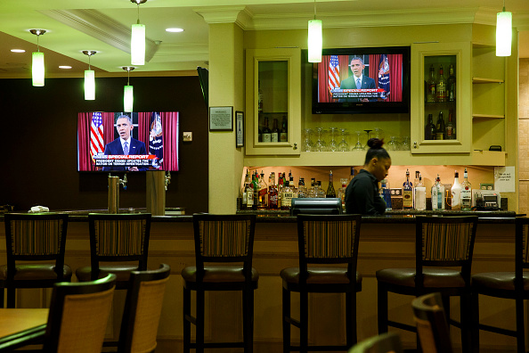 A bartender at a hotel near the Inland Regional Center watches President Obama speak on TV during the aftermath of a mass shooting that killed 14 people on Sunday, December 6, 2015 in San Bernardino, California.